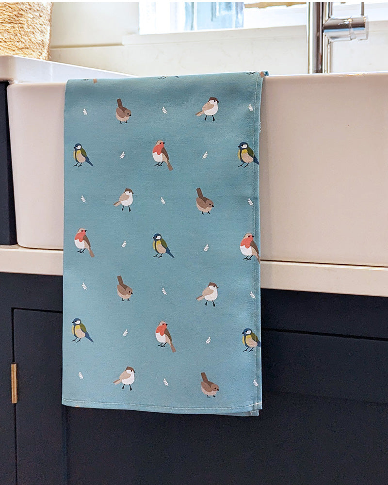 Towel with bird pattern hanging on a kitchen sink