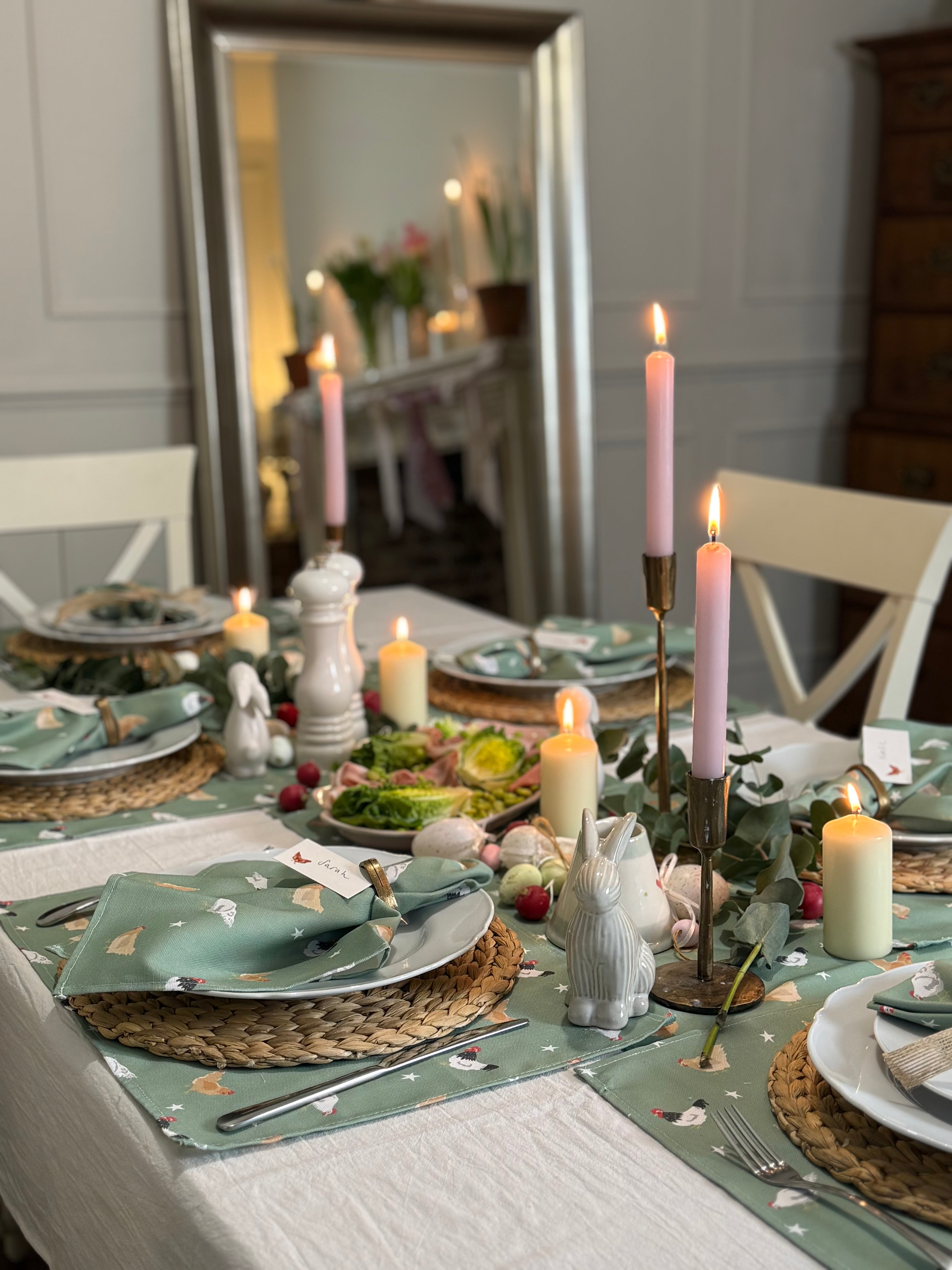 Elegant Easter table setting with chicken table linens, candles and decorative elements.