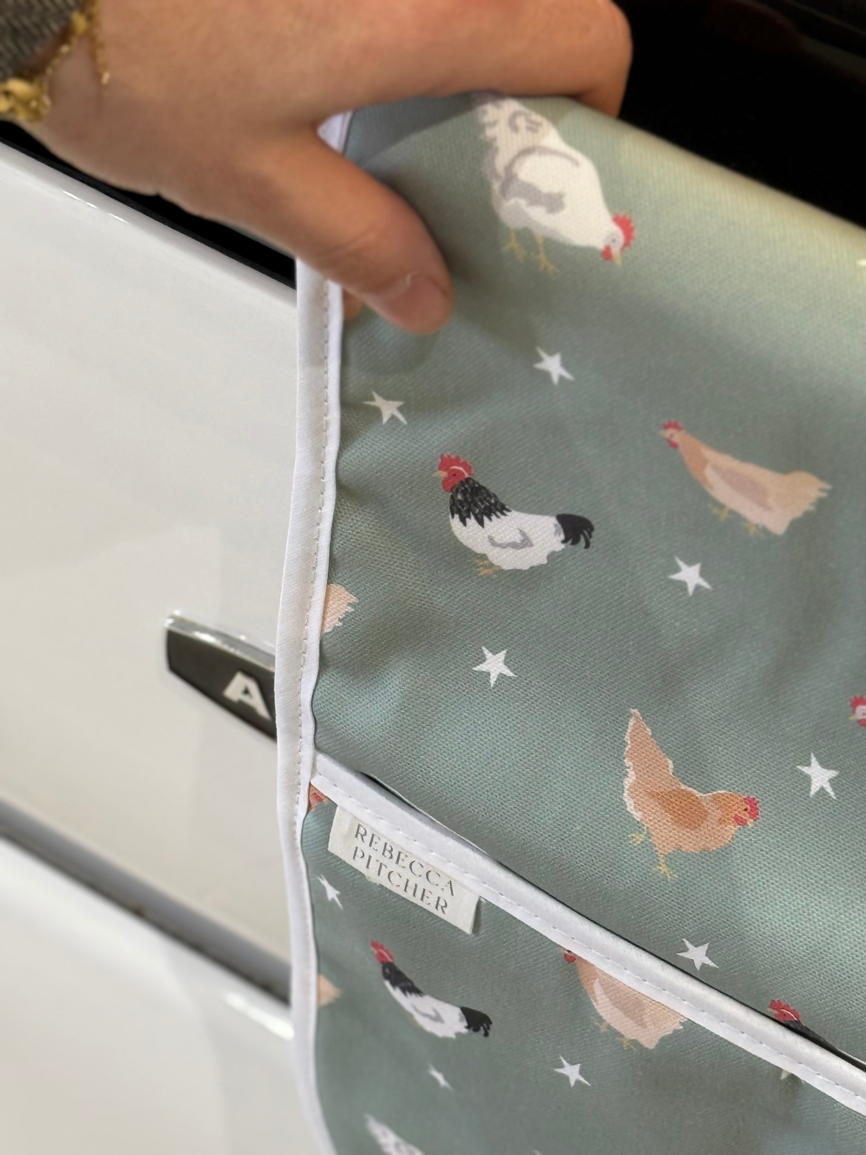 hand touching a chicken design ovenglove