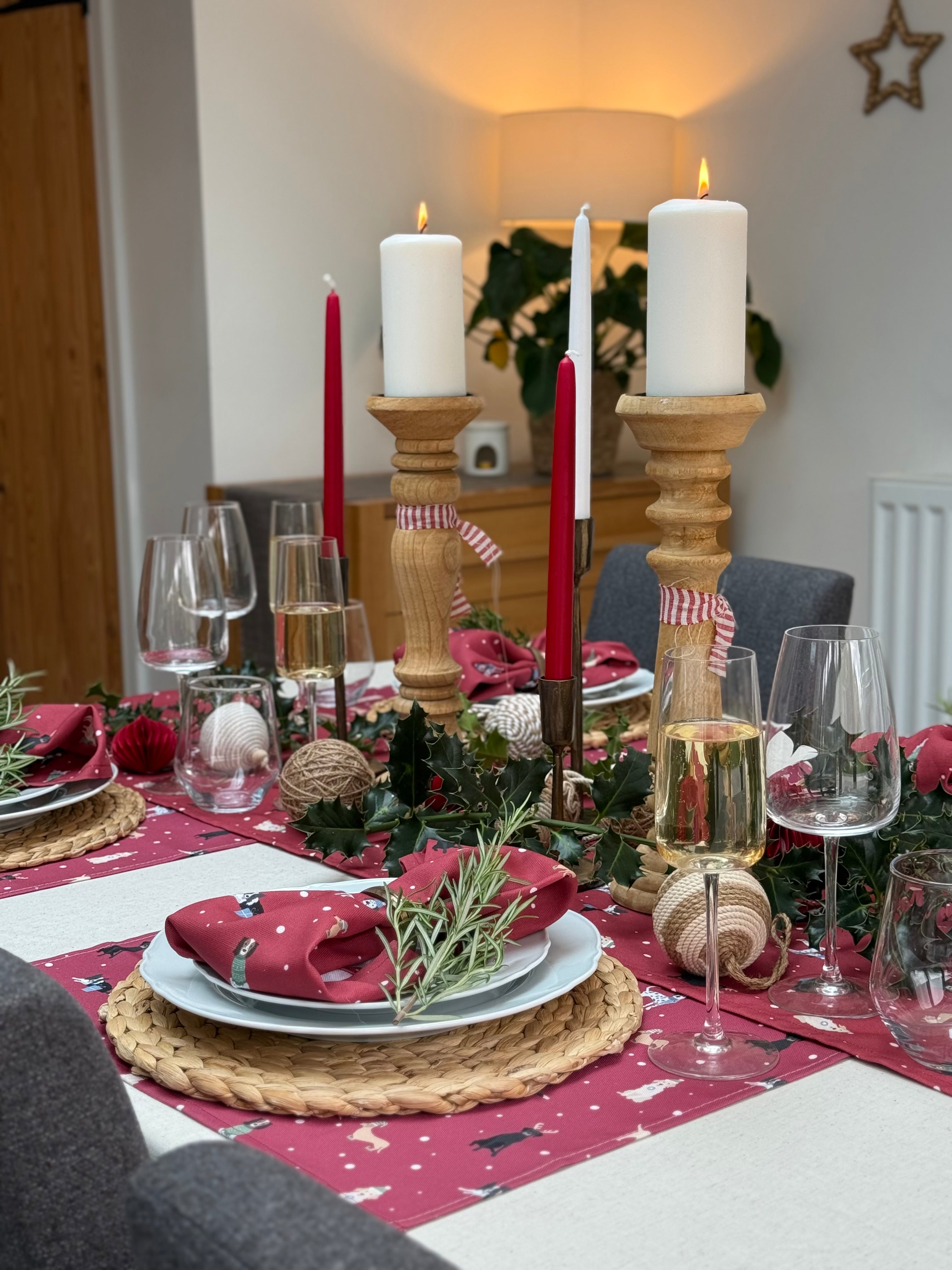 Dining table set for a festive meal with Christmas dogs design placemats, napkins and runner.