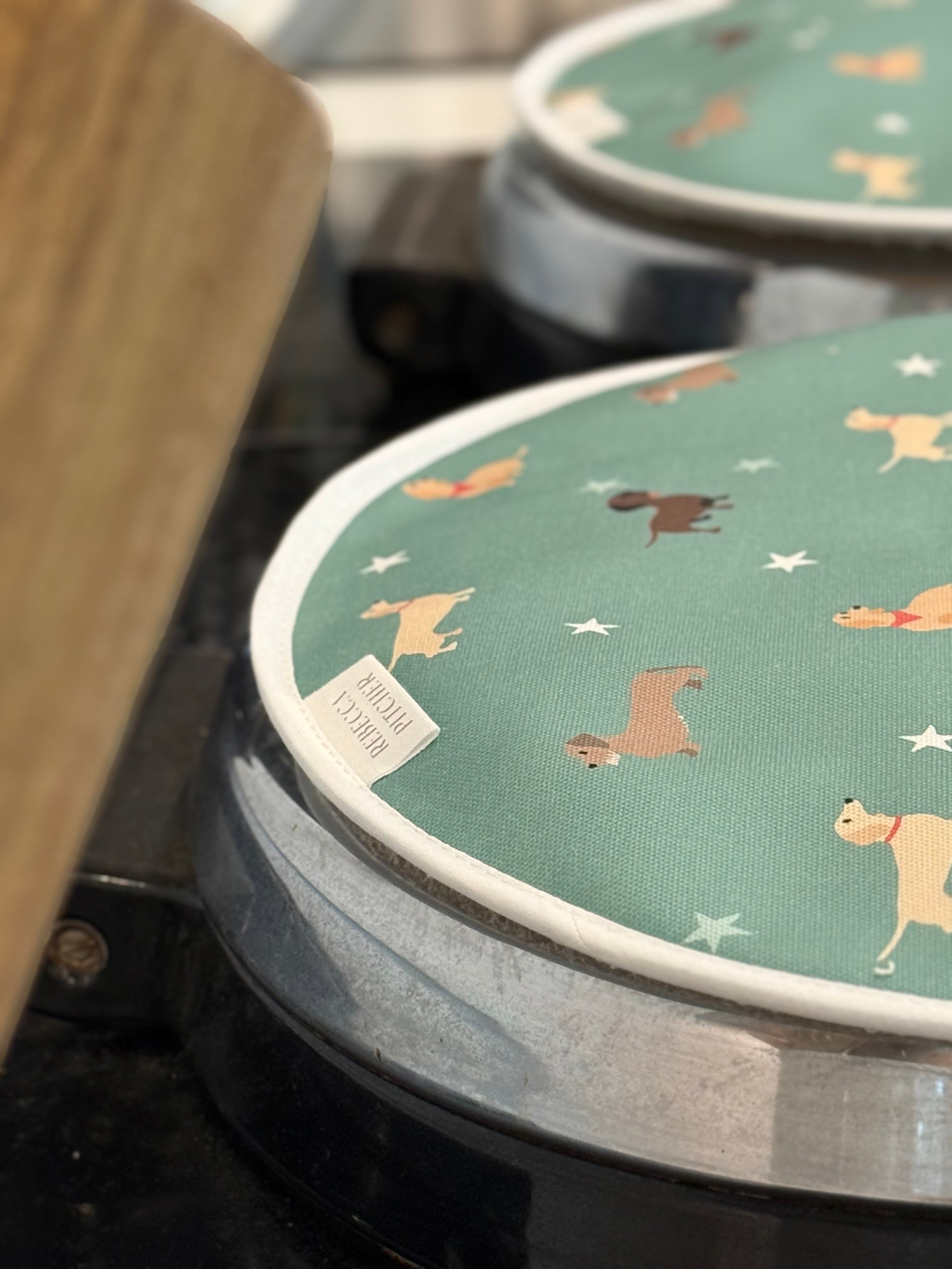 close up of green dachshund design round hob covers