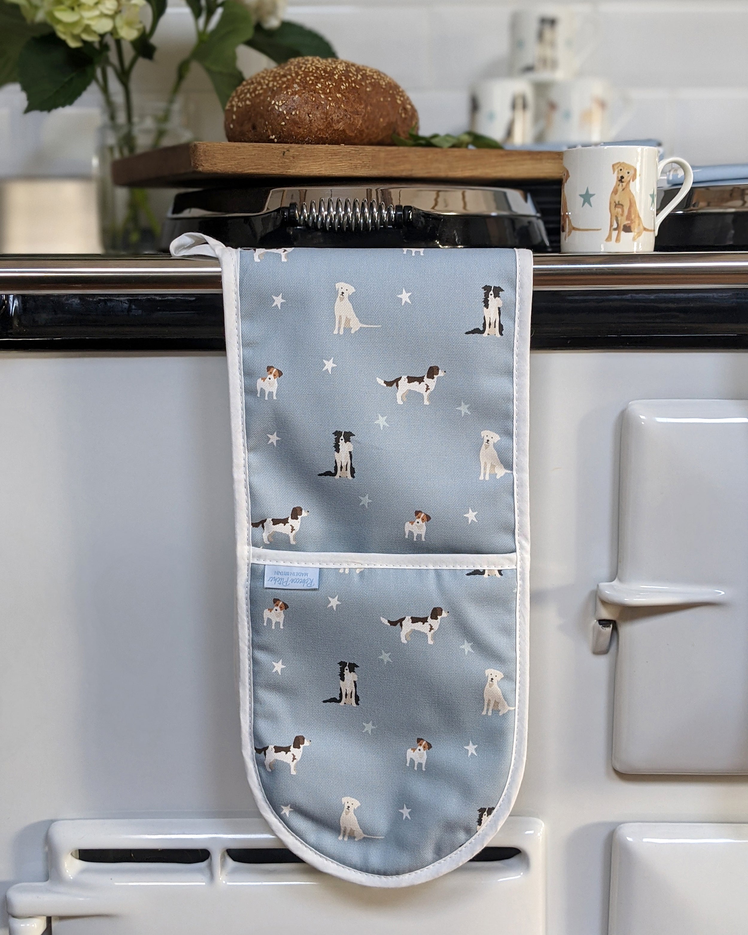 Oven mitt with dog pattern hanging on a kitchen range cooker