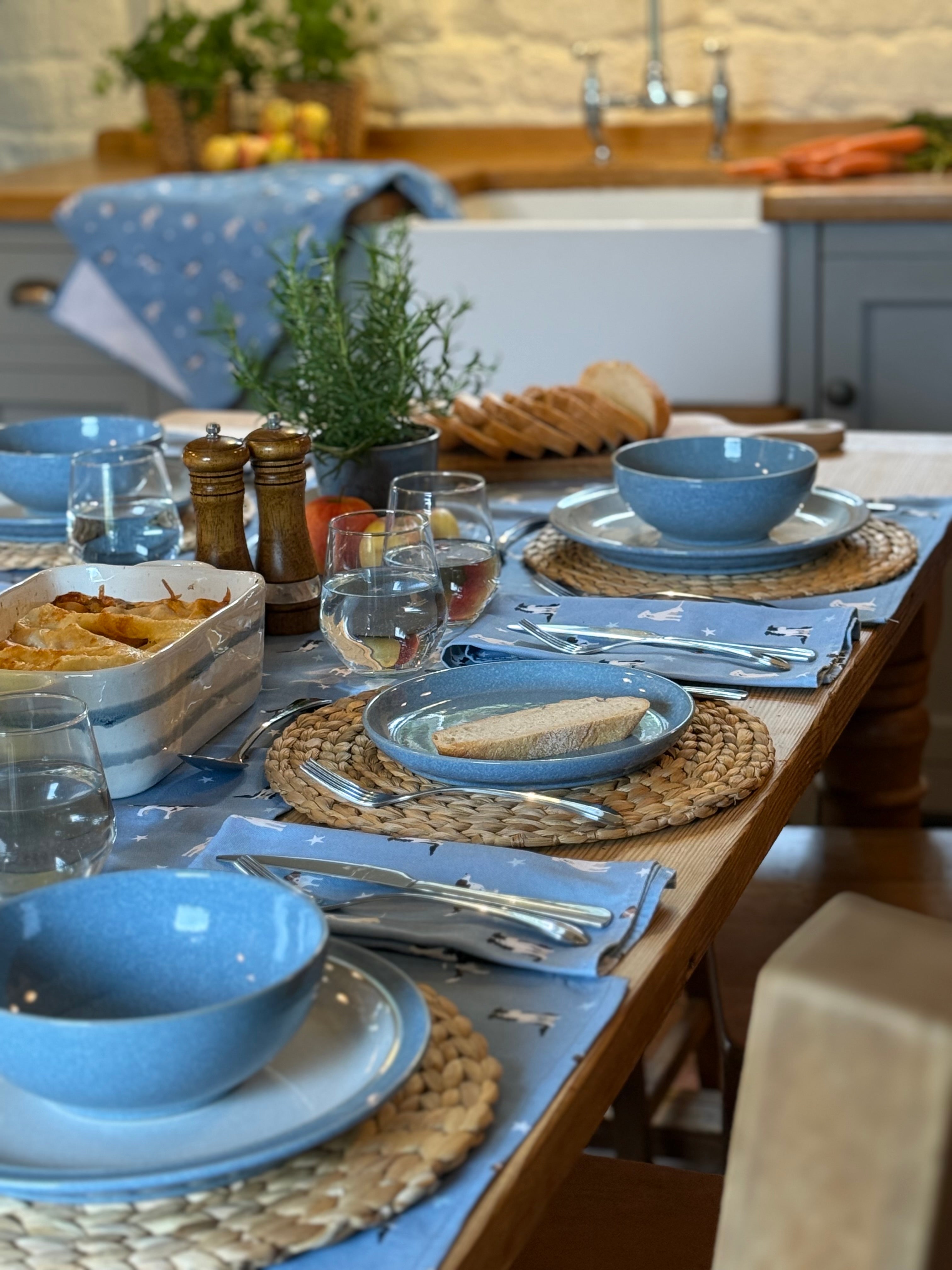 Dining table set with blue dog print table linens in a kitchen.