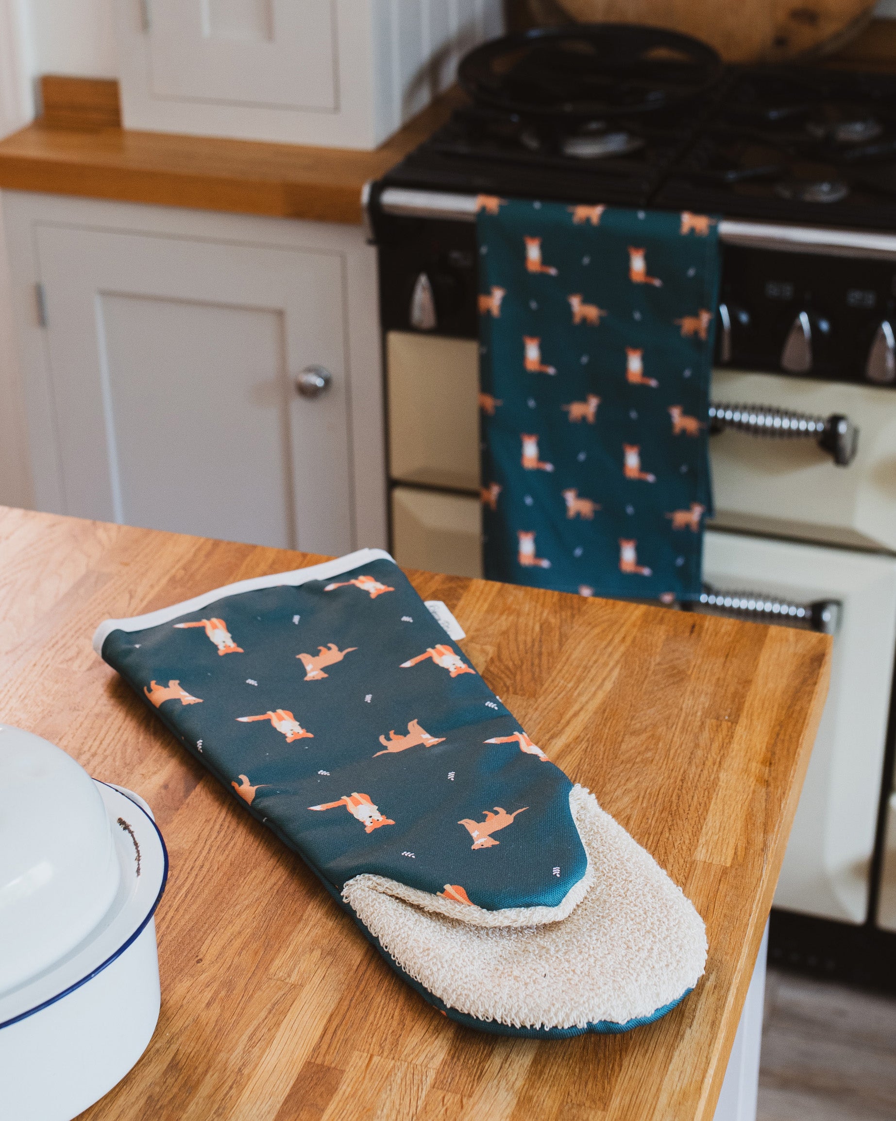 Oven Gauntlet with fox pattern on a wooden kitchen counter