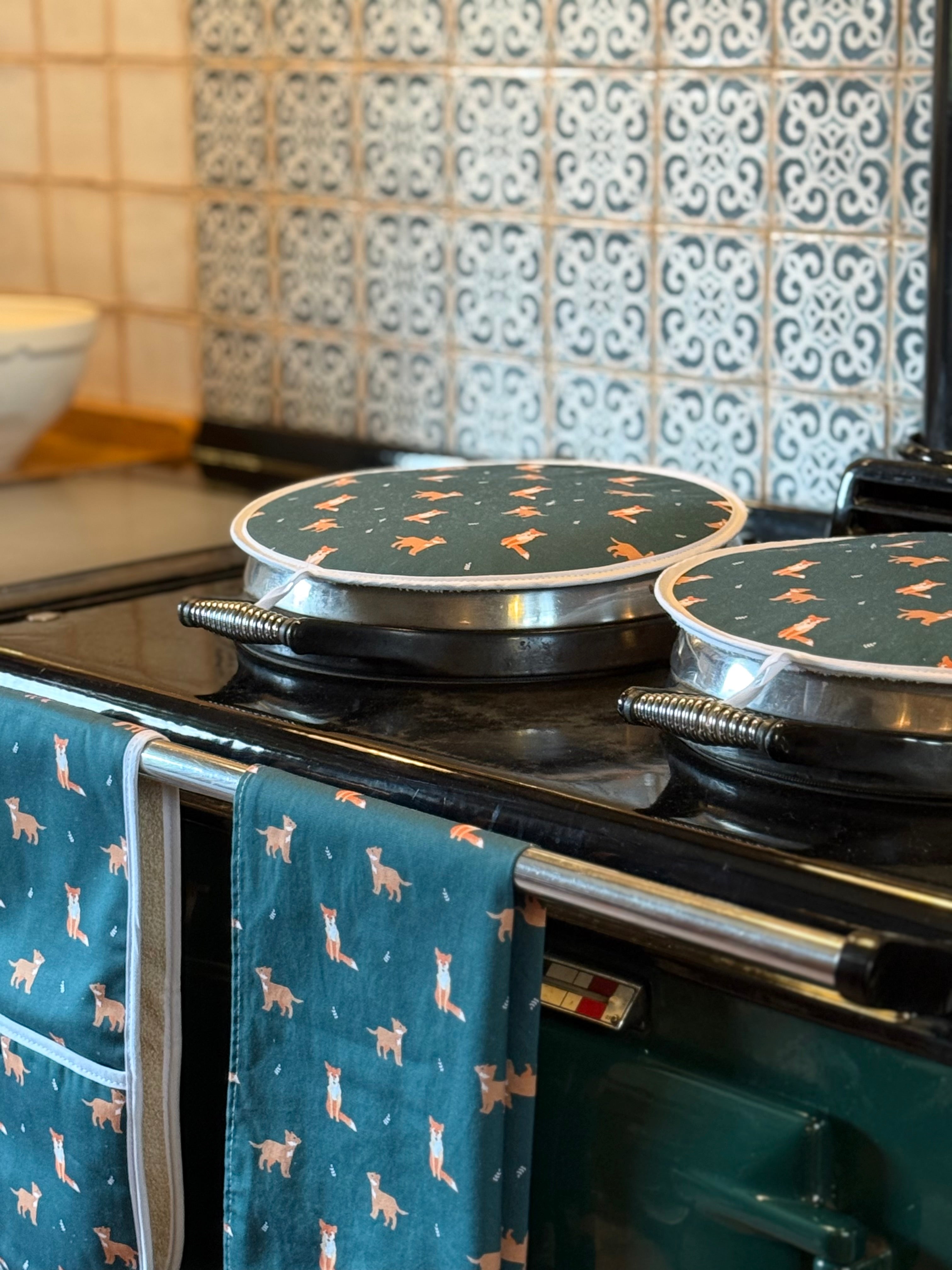 Green fox patterned kitchen textiles on a country kitchen range cooker