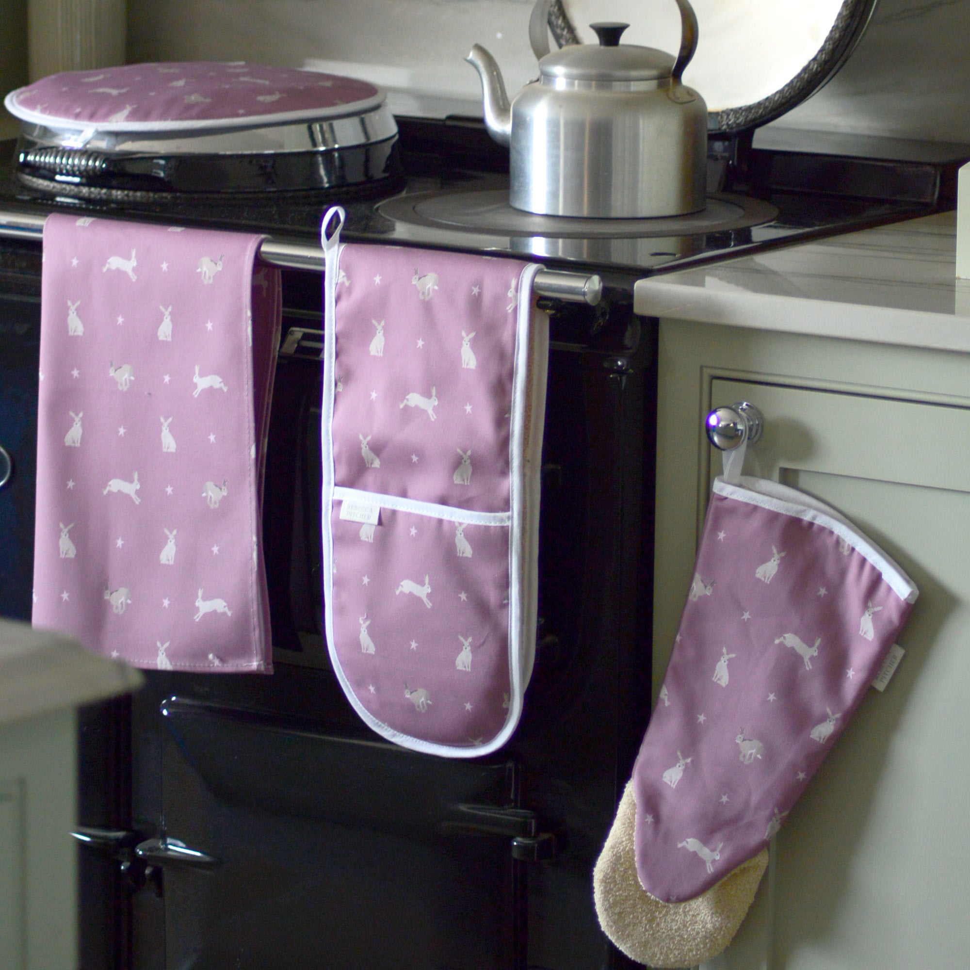 Pink Hare Design Hob Cover, Oven Gloves, Gauntlet and Tea Towel in a kitchen