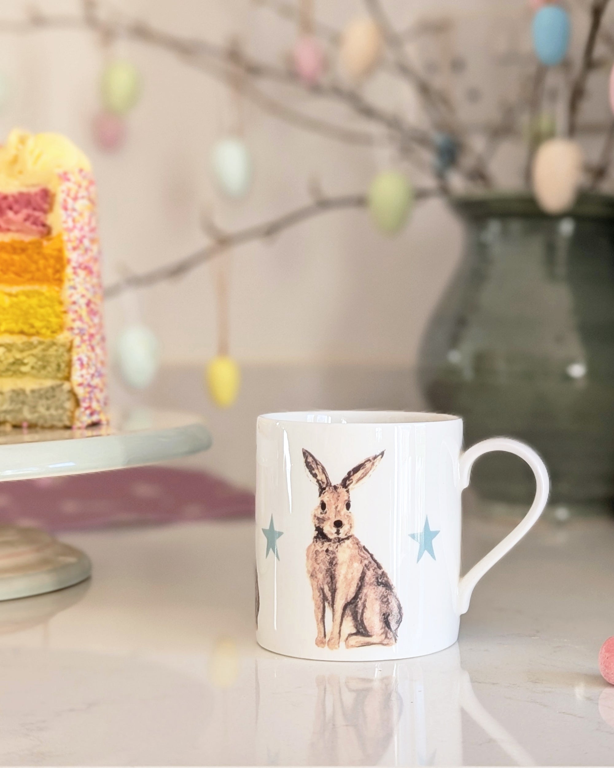 China mug with a hare design on a table with Easter decorations in the background