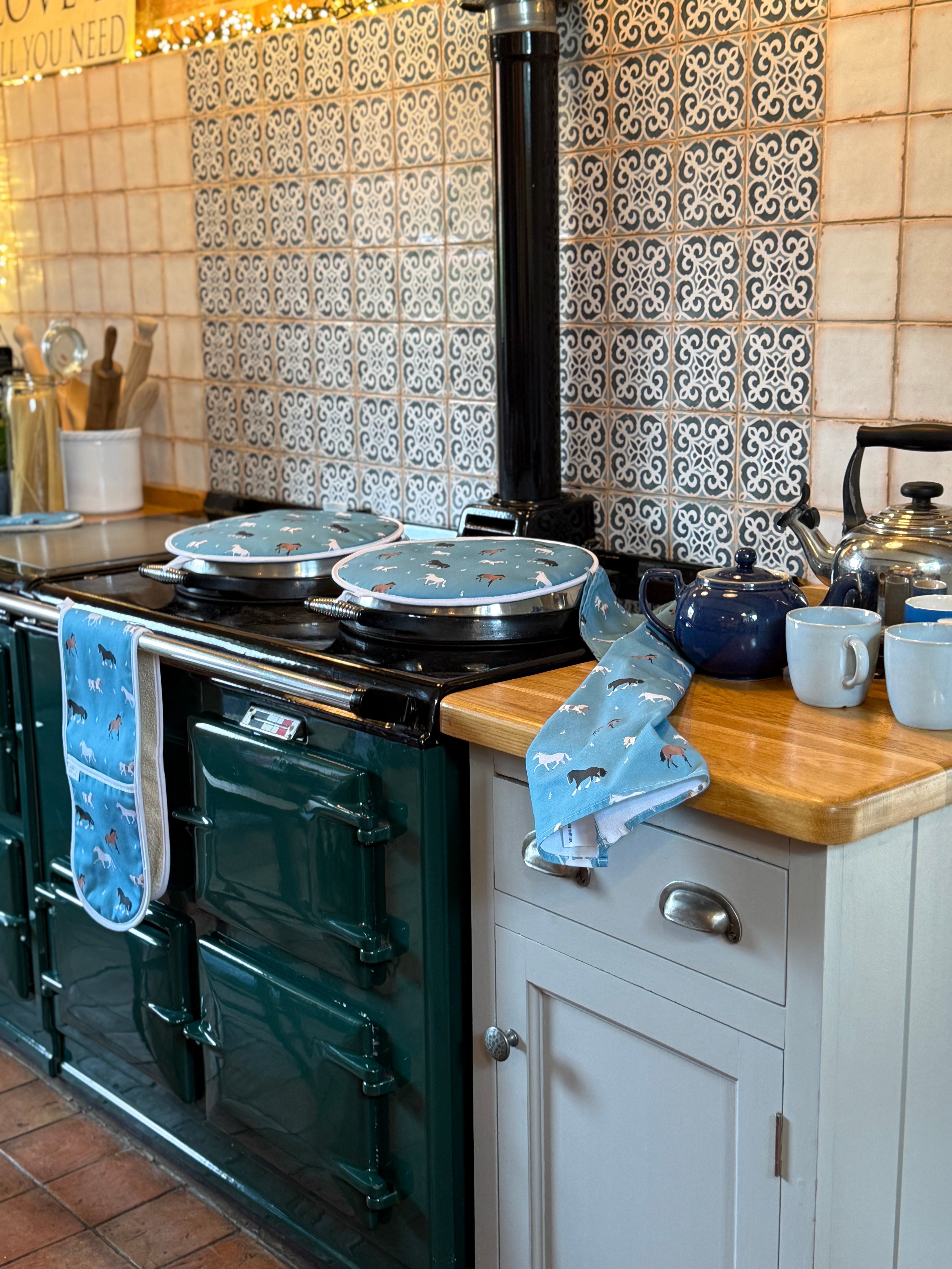 Blue horses pattern hob covers, oven gloves and tea towel in a country kitchen