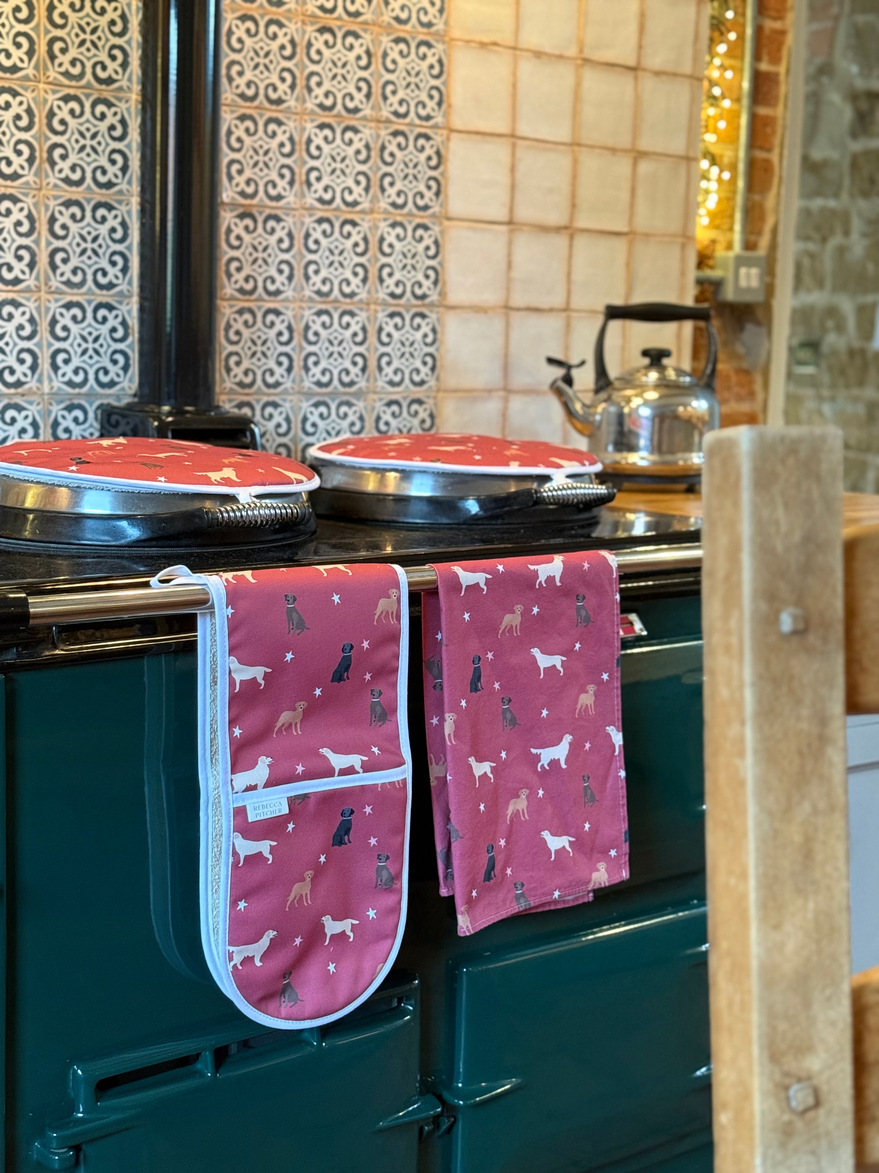 Red labrador design oven gloves, tea towel and hob covers on a country range cooker