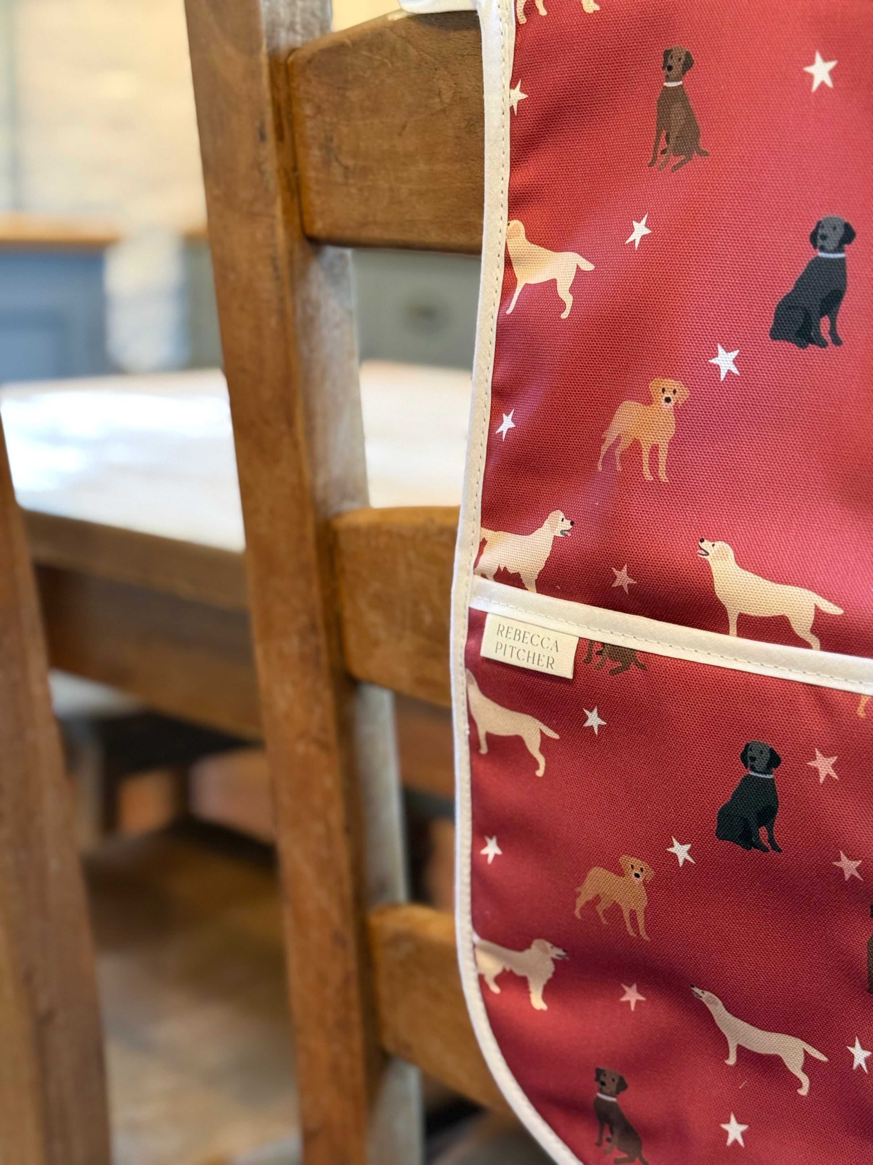 close up of red labrador design oven mitts hanging on a chair