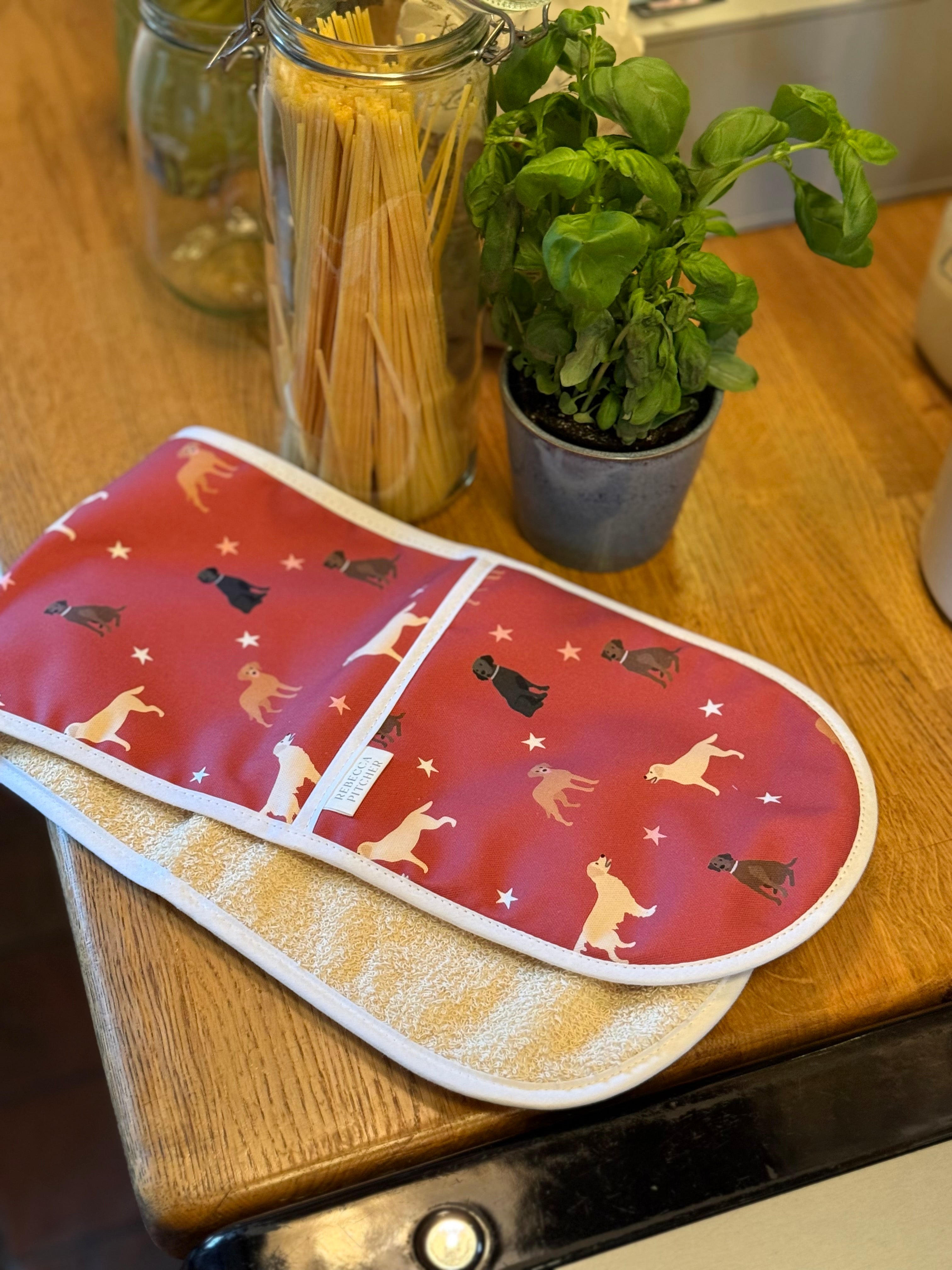 Red labrador print double ovengloves on a wooden kitchen surface