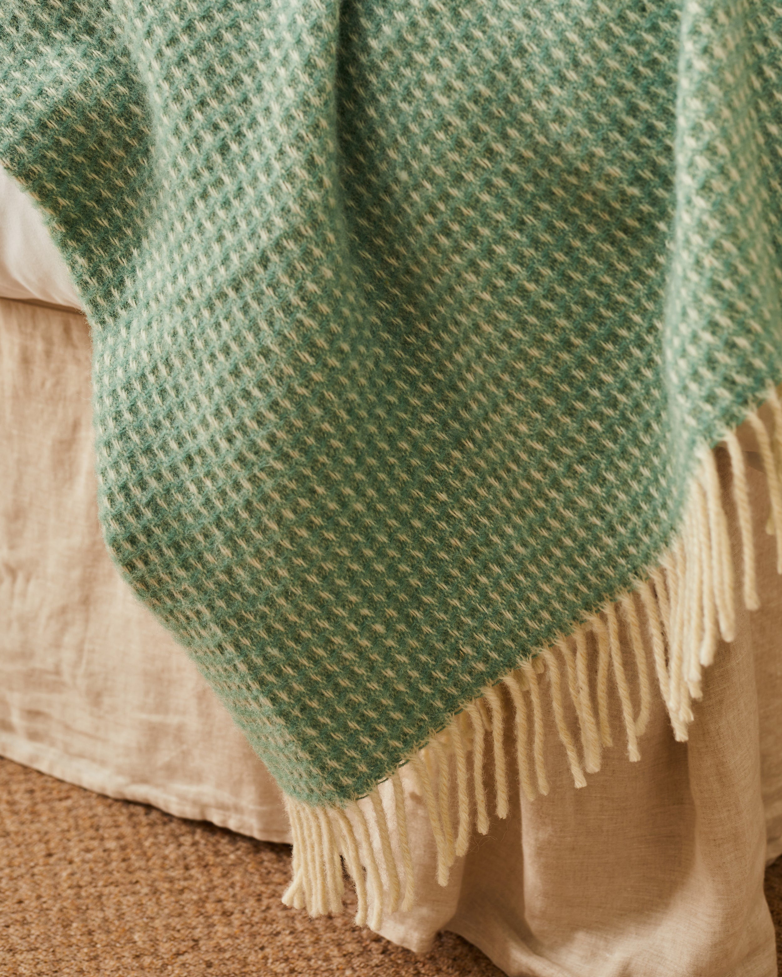close up detail of a sea green wool blanket