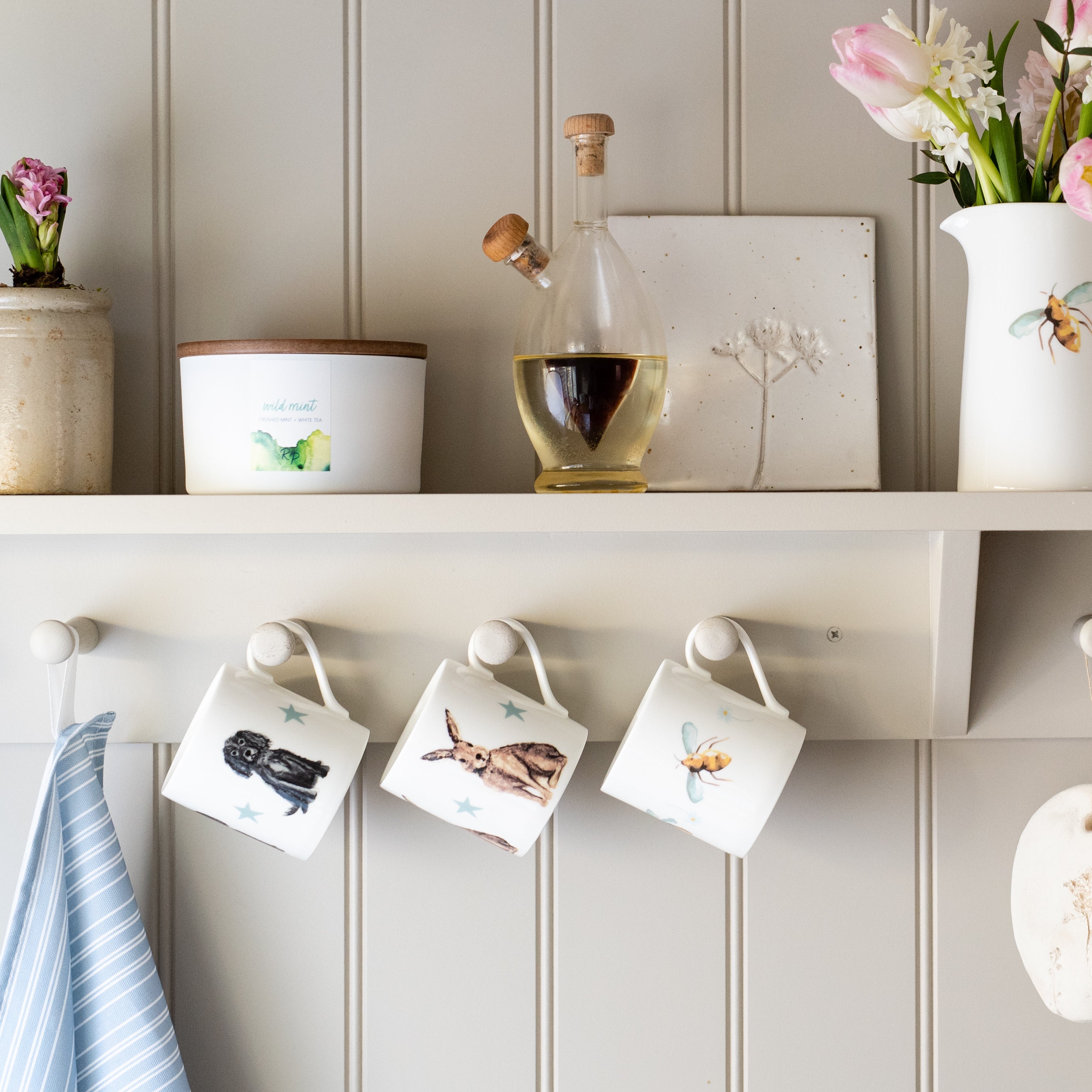 Fine Bone China Mugs by Rebecca Pitcher hanging on a shelf in a country kitchen
