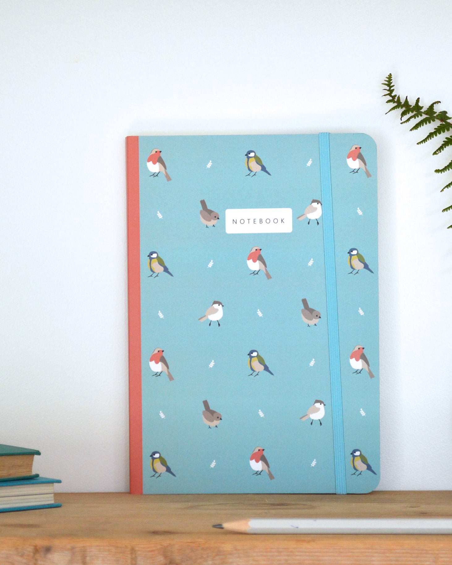 Notebook with bird pattern on a wooden surface