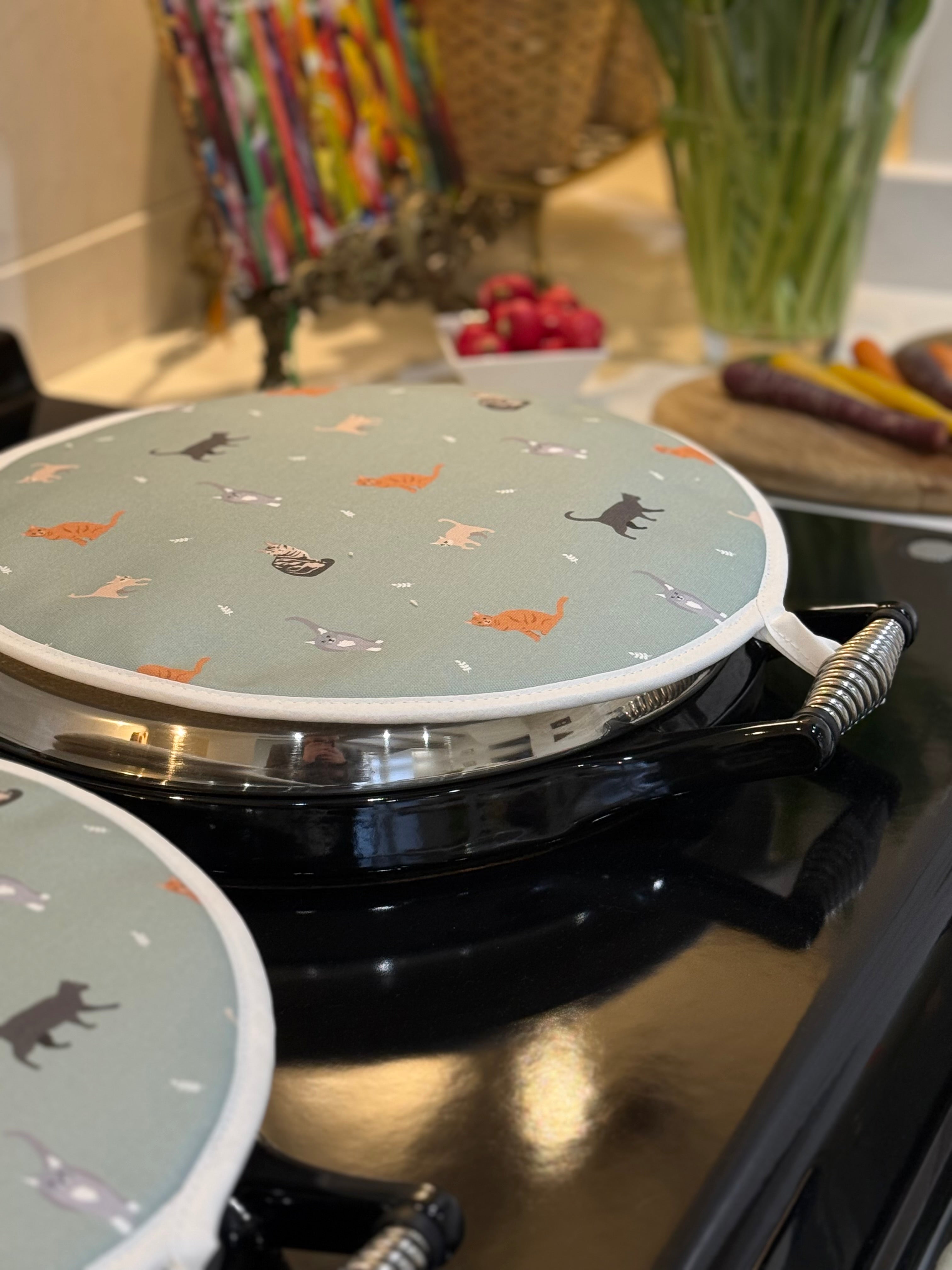 Round hob cover with cat pattern on a kitchen range cooker