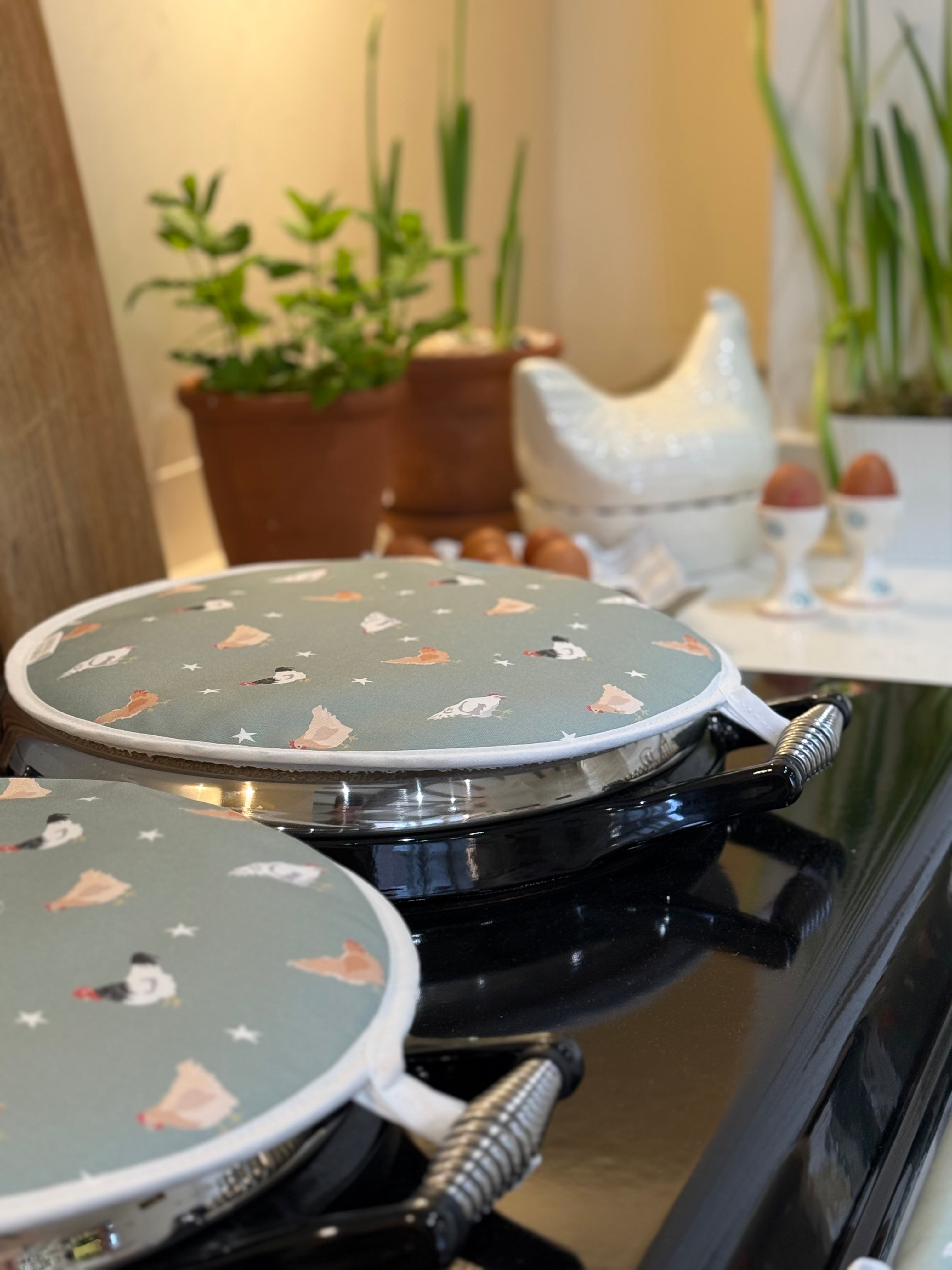 Chicken design hob covers on a stove top in a kitchen setting