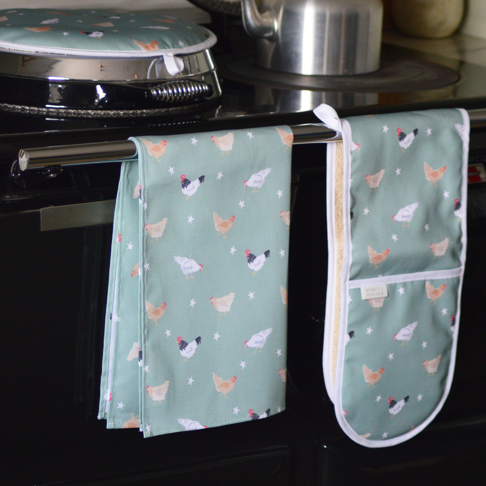 Green chicken design tea towel on an aga cooker rail