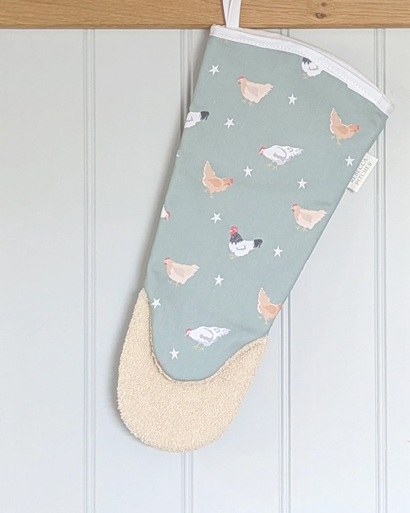 Oven mitt with chicken pattern on a light green background