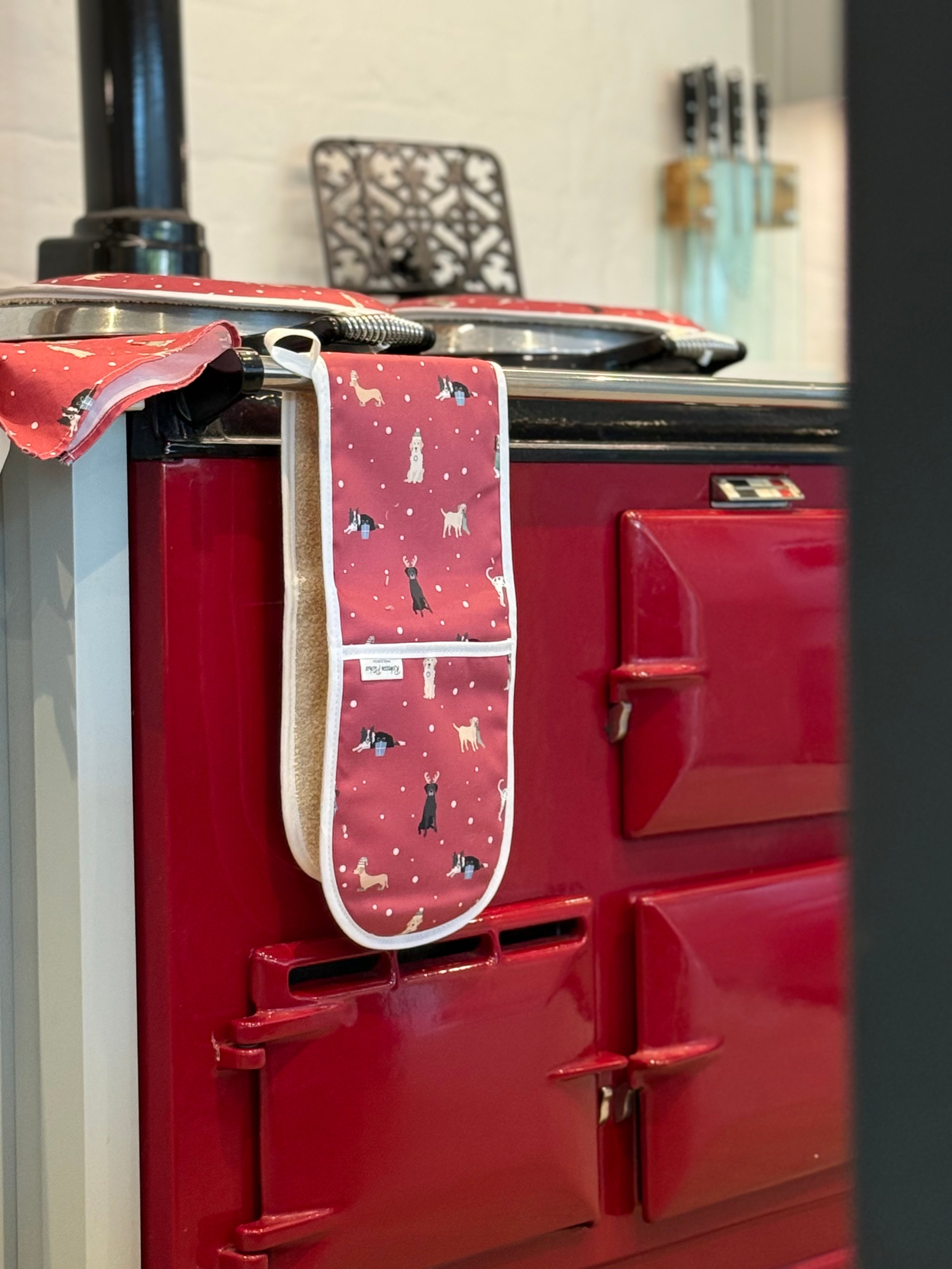 Red Aga range cooker with a Christmas dogs patterned oven mitt hanging on it