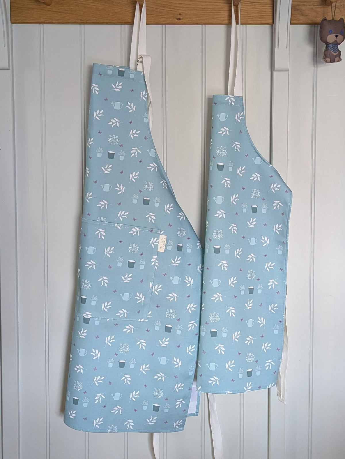 Childrens apron in duckegg cotton fabric hanging on a kitchen wall