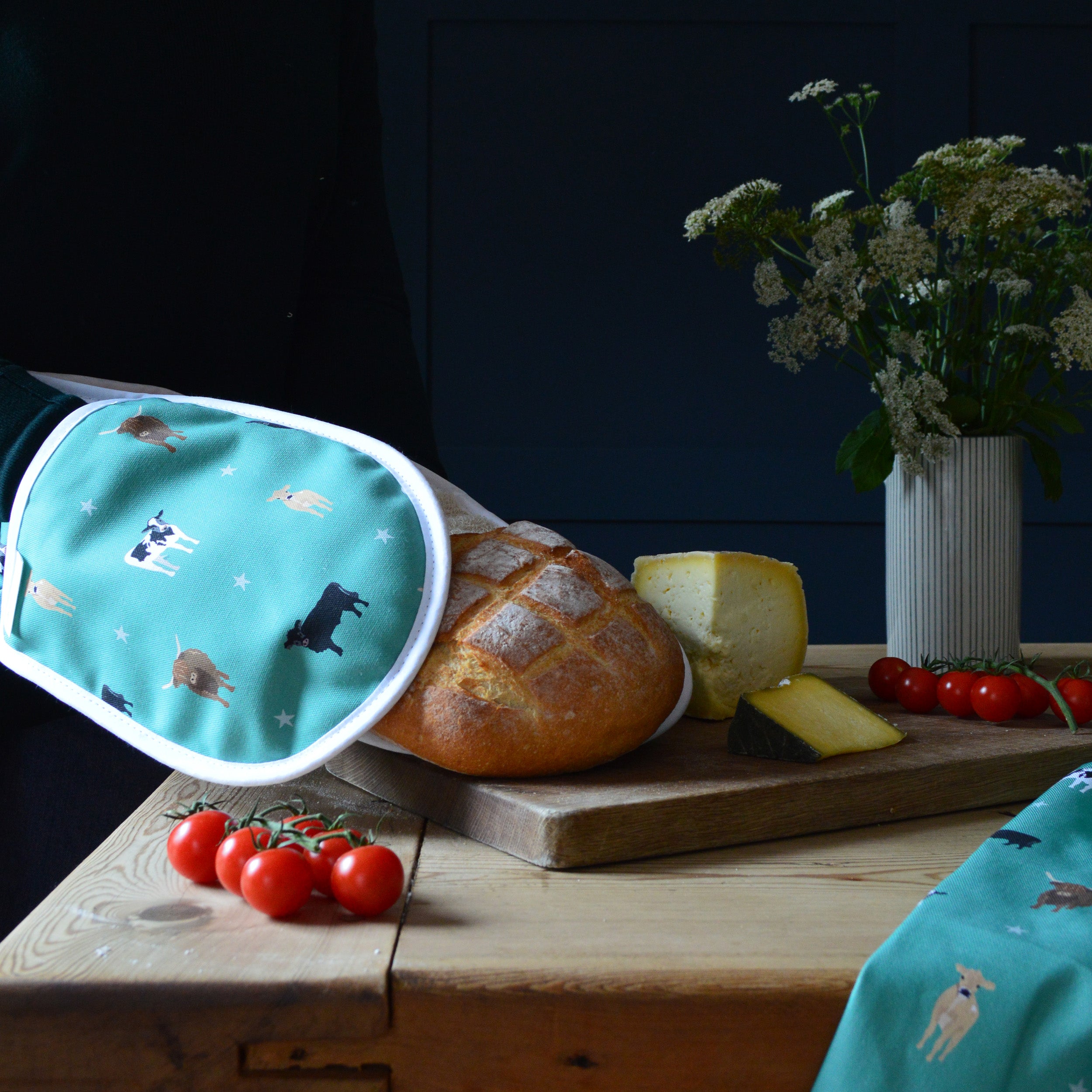 Green Cow Oven gloves holding a loaf of bread