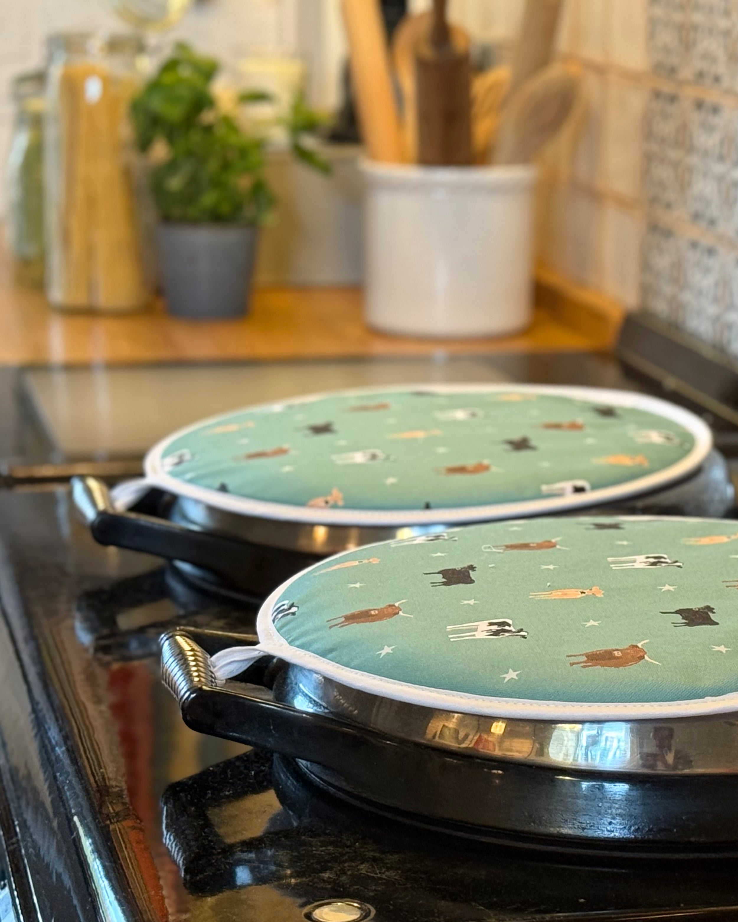 Green cow pattern round hob covers on a country kitchen range cooker