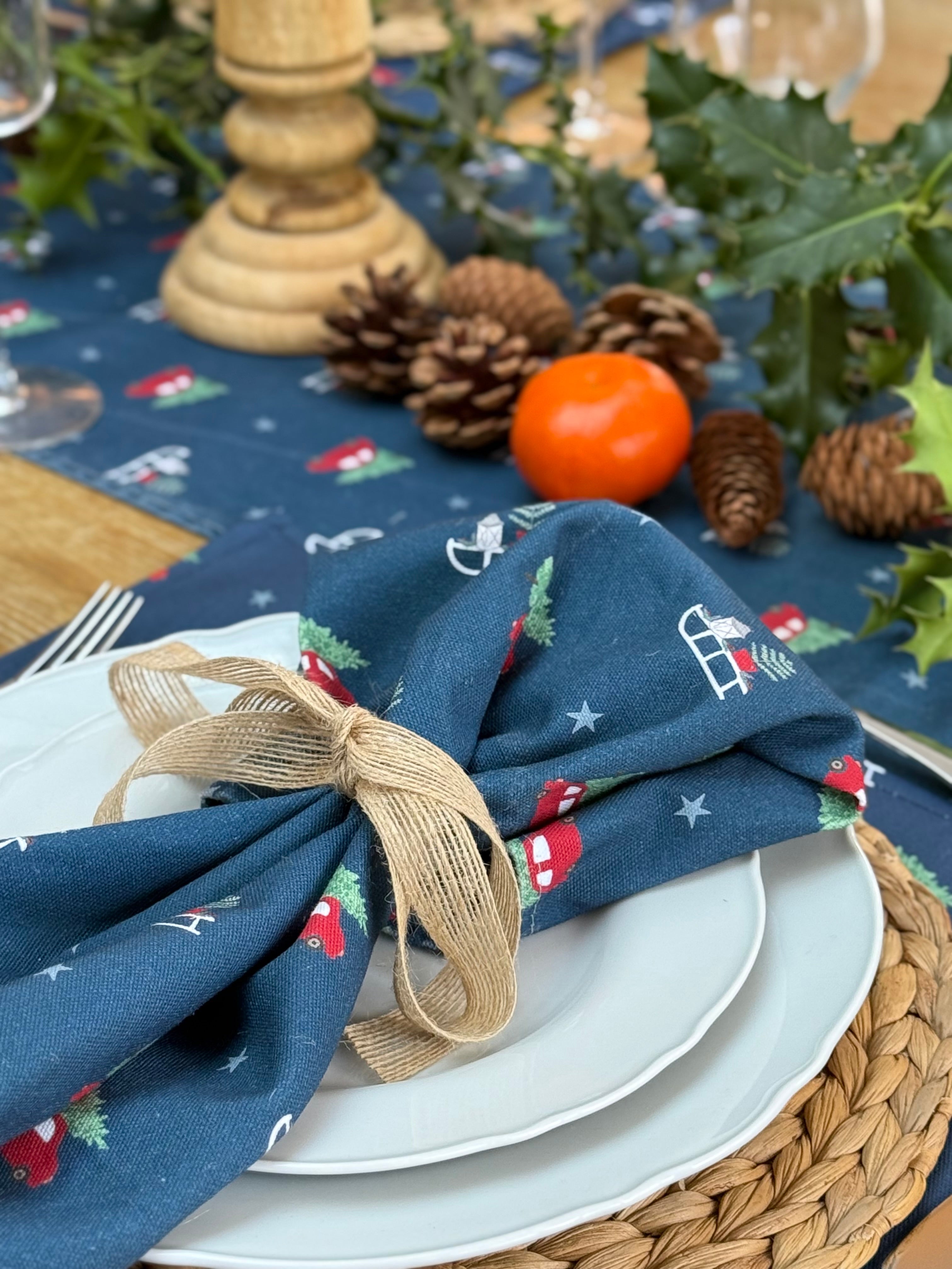Decorative table setting with a blue napkin, white plates, and festive decorations.