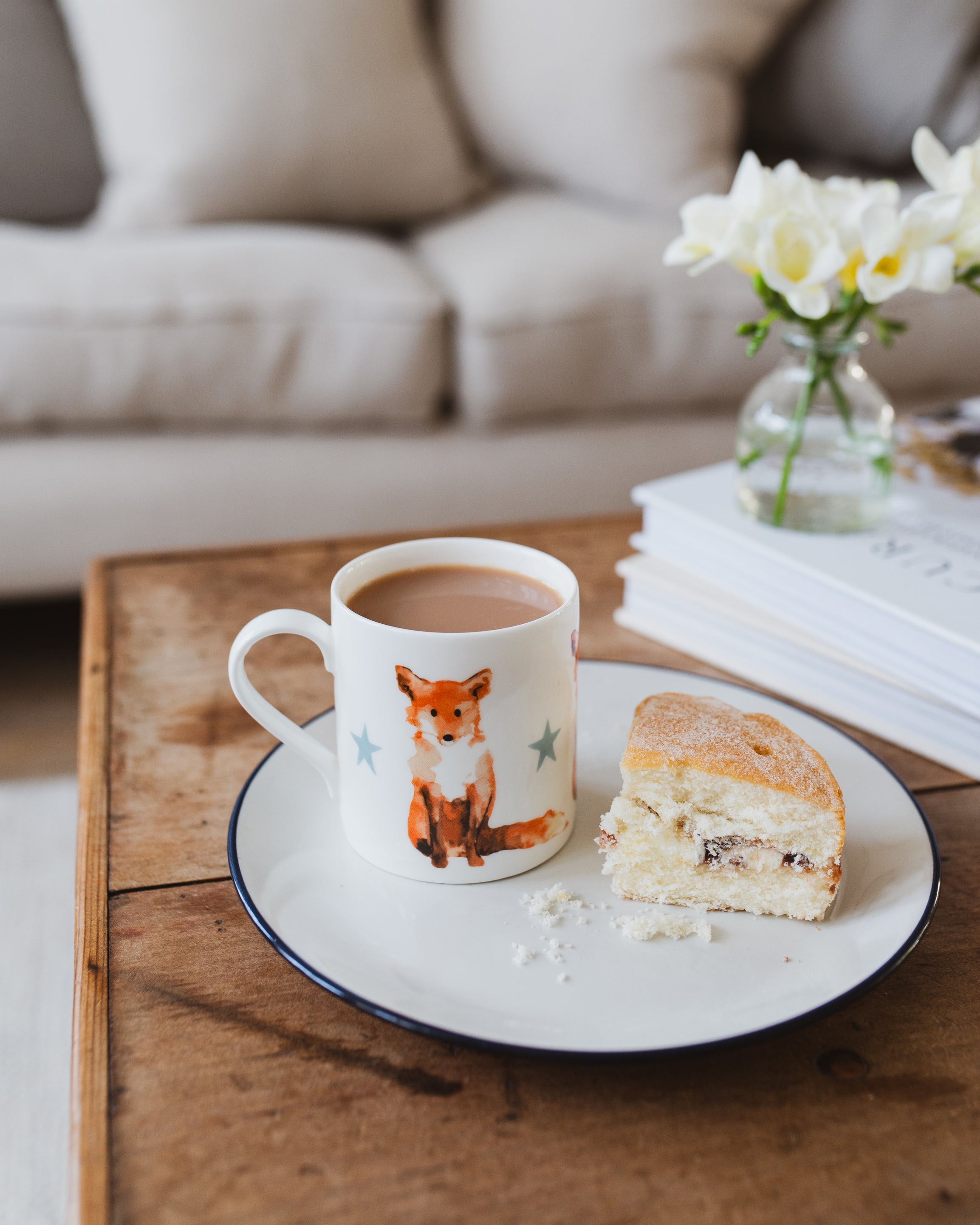Fox-themed mug with a slice of cake on a wooden table