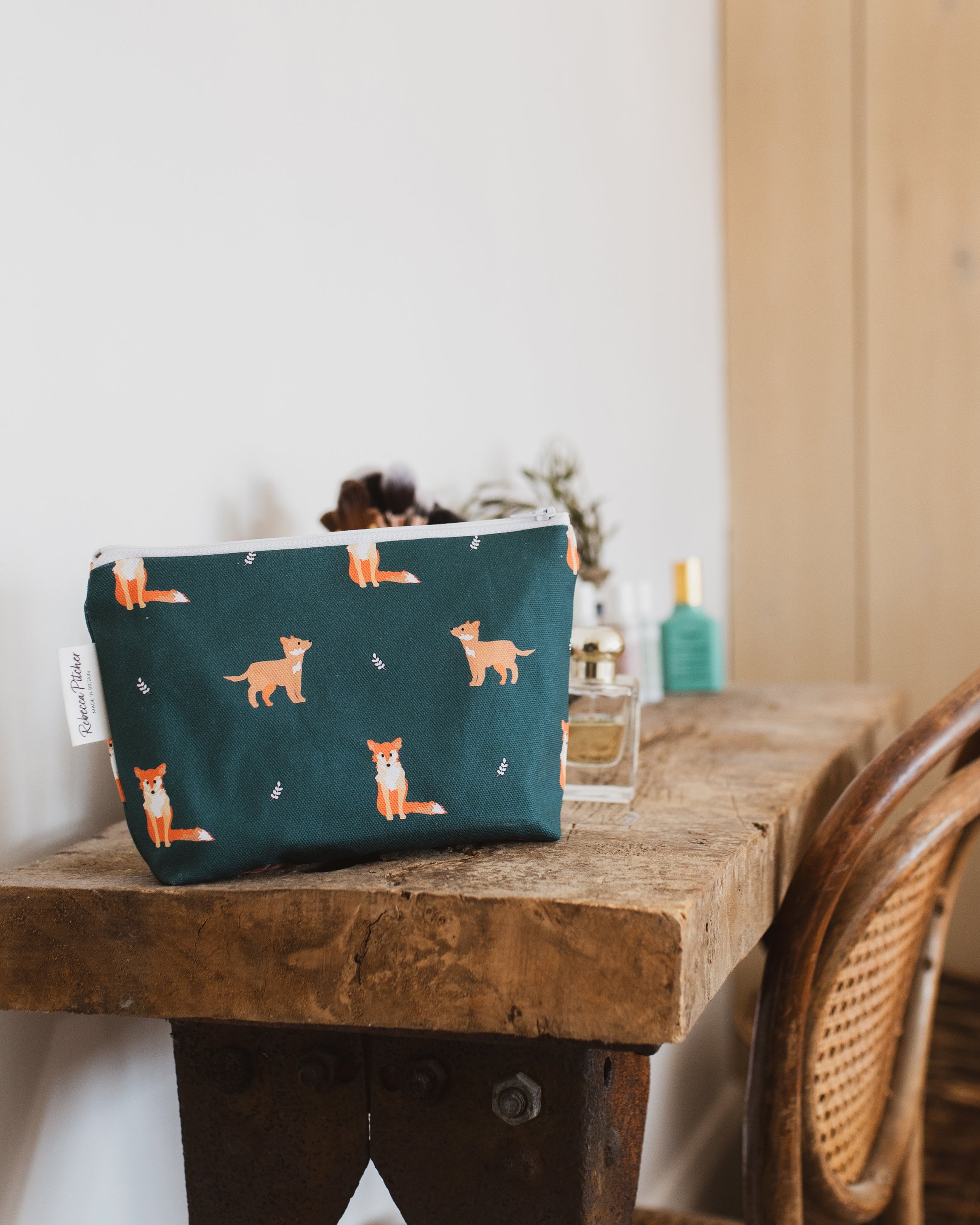 Green pouch with fox pattern on a wooden table