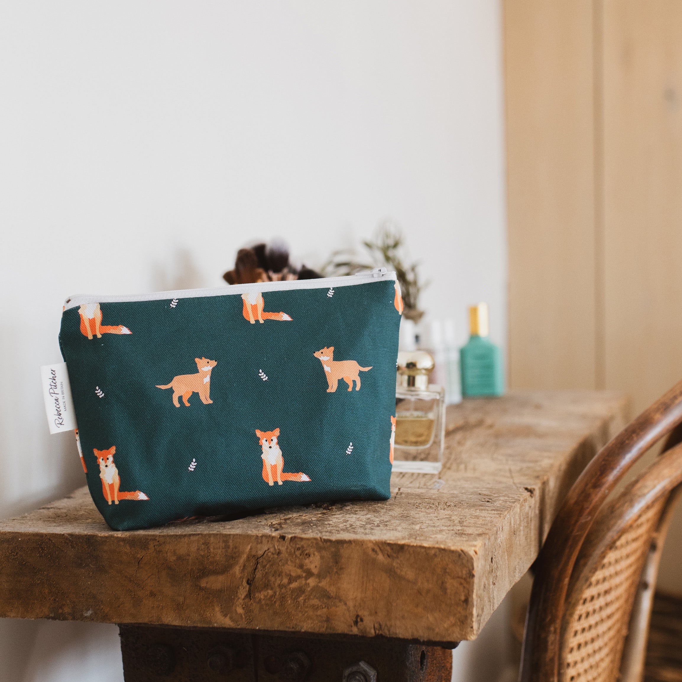 dark green makeup bag with fox illustrations