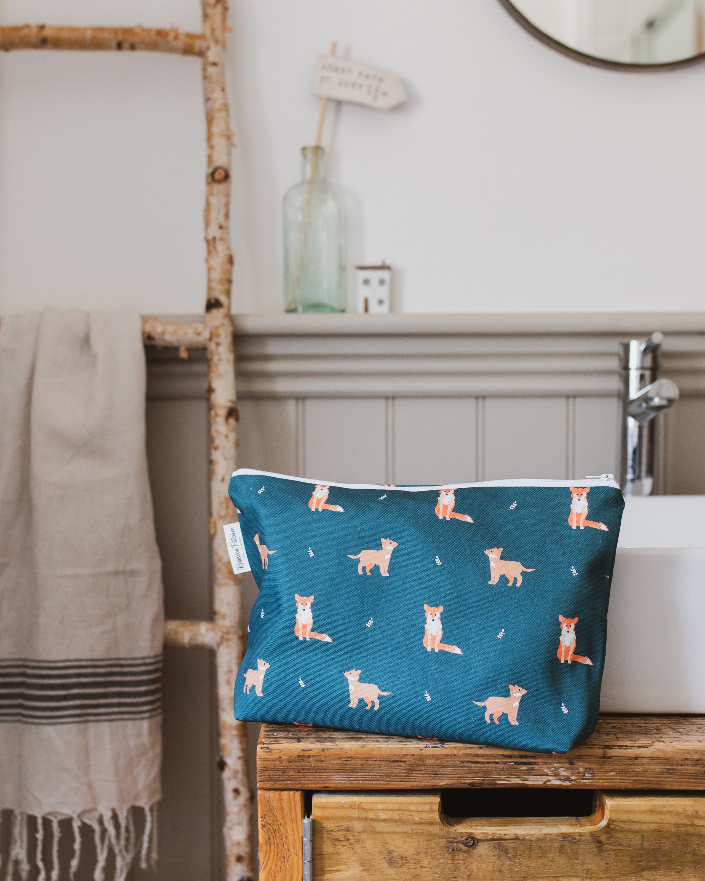 Dark Green washbag with fox pattern on a wooden shelf in a rustic bathroom setting