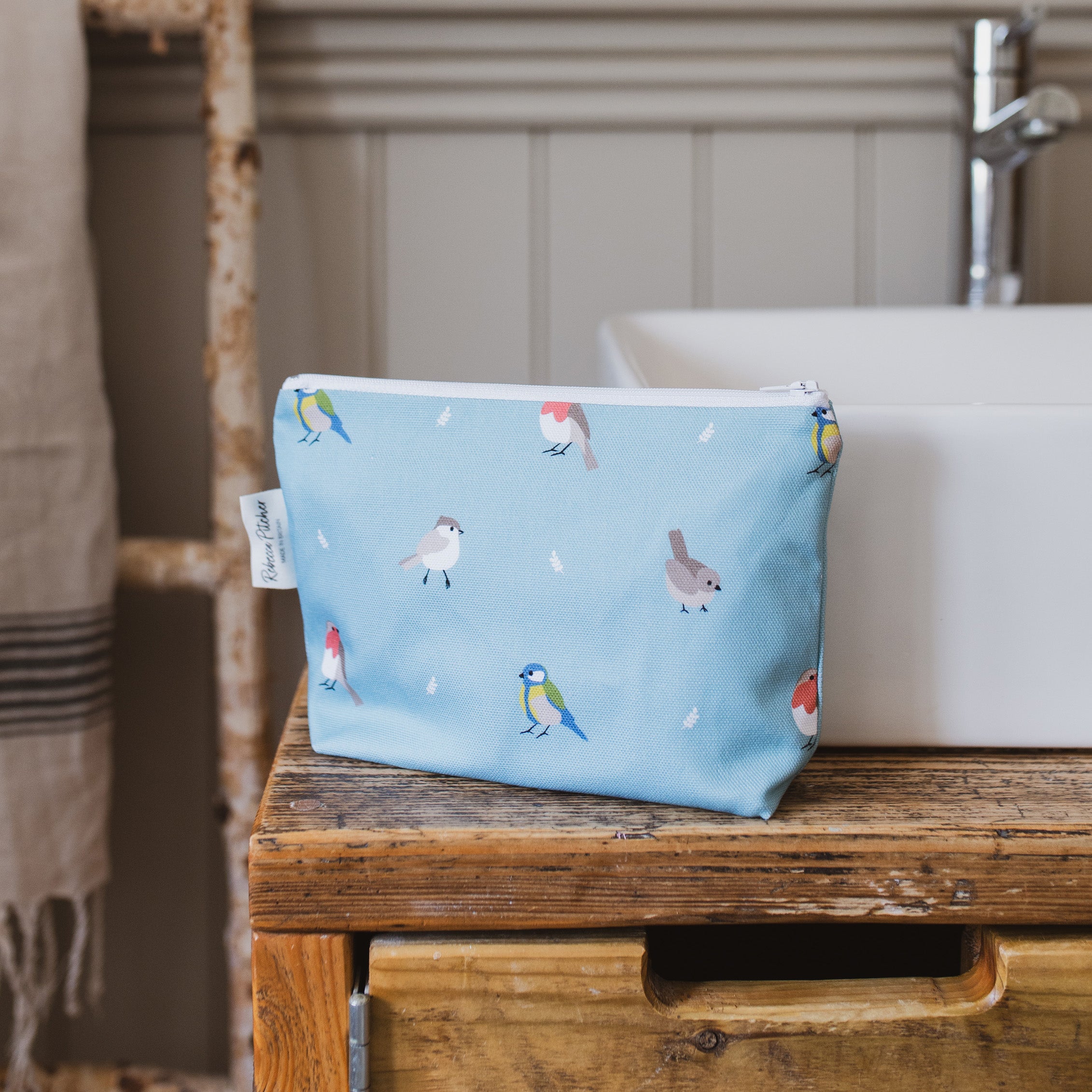 Garden Birds Makeup Bag by a sink