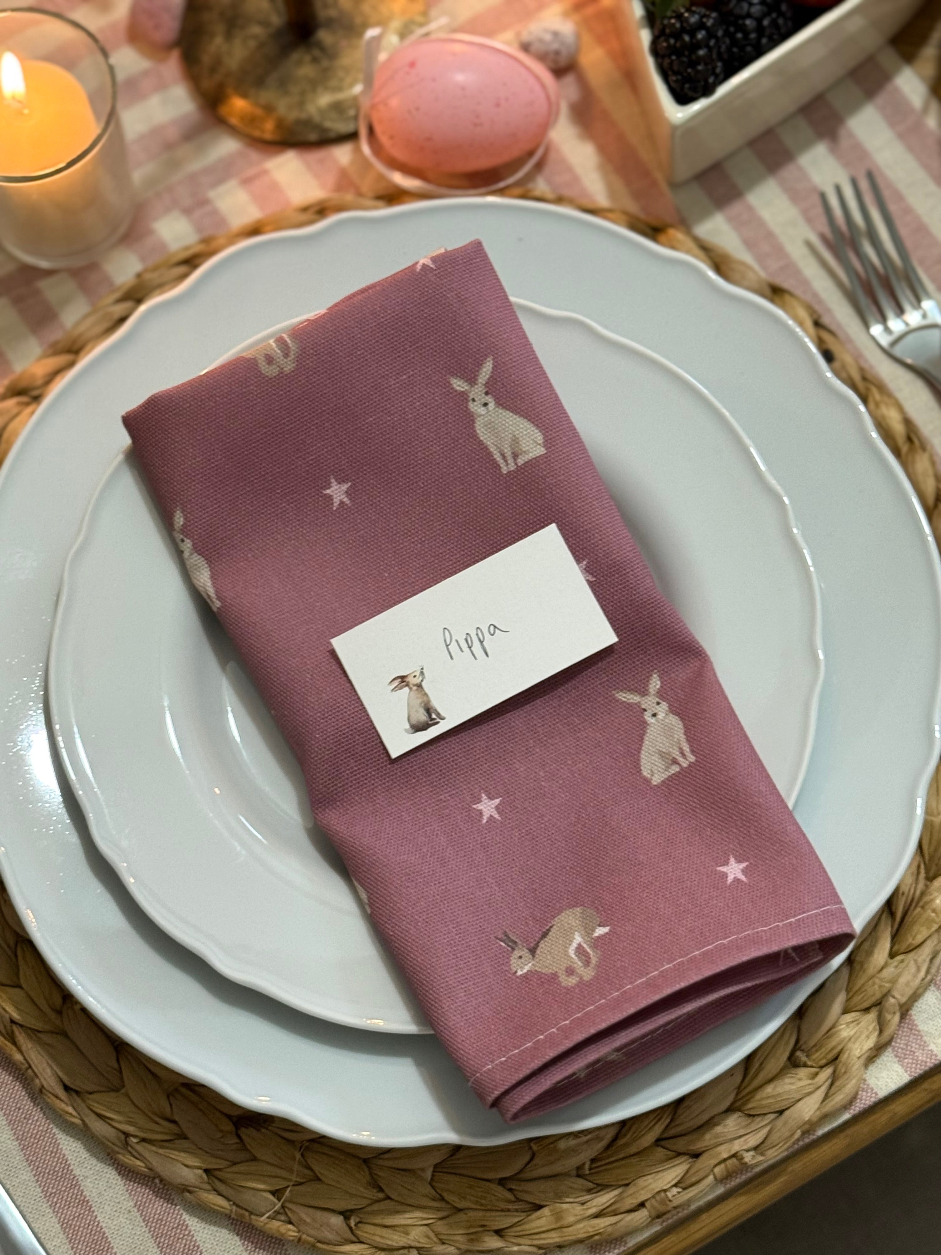 Pink hare design cotton napkin on a white plate with place name