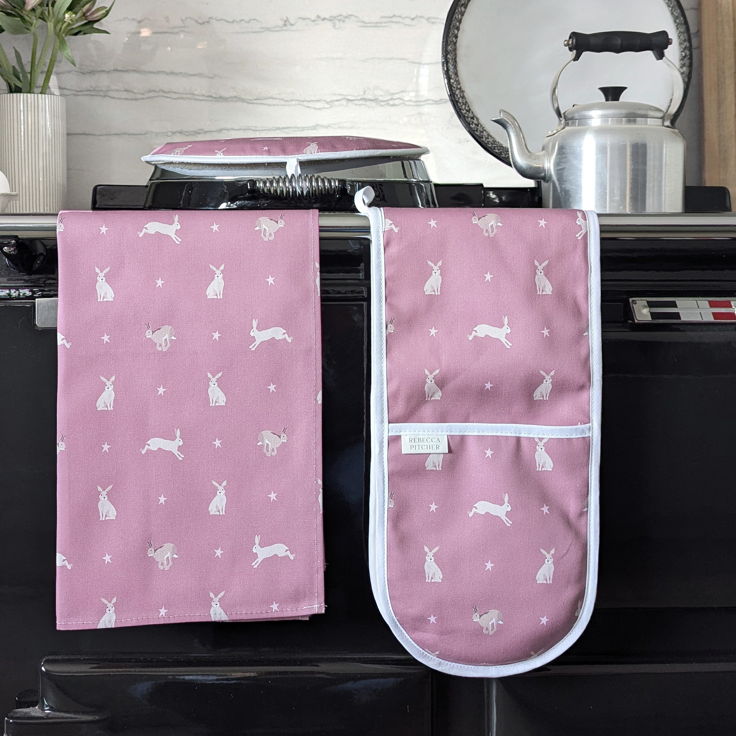 Pink Hare design Tea towel and Ovengloves on a cooker rail