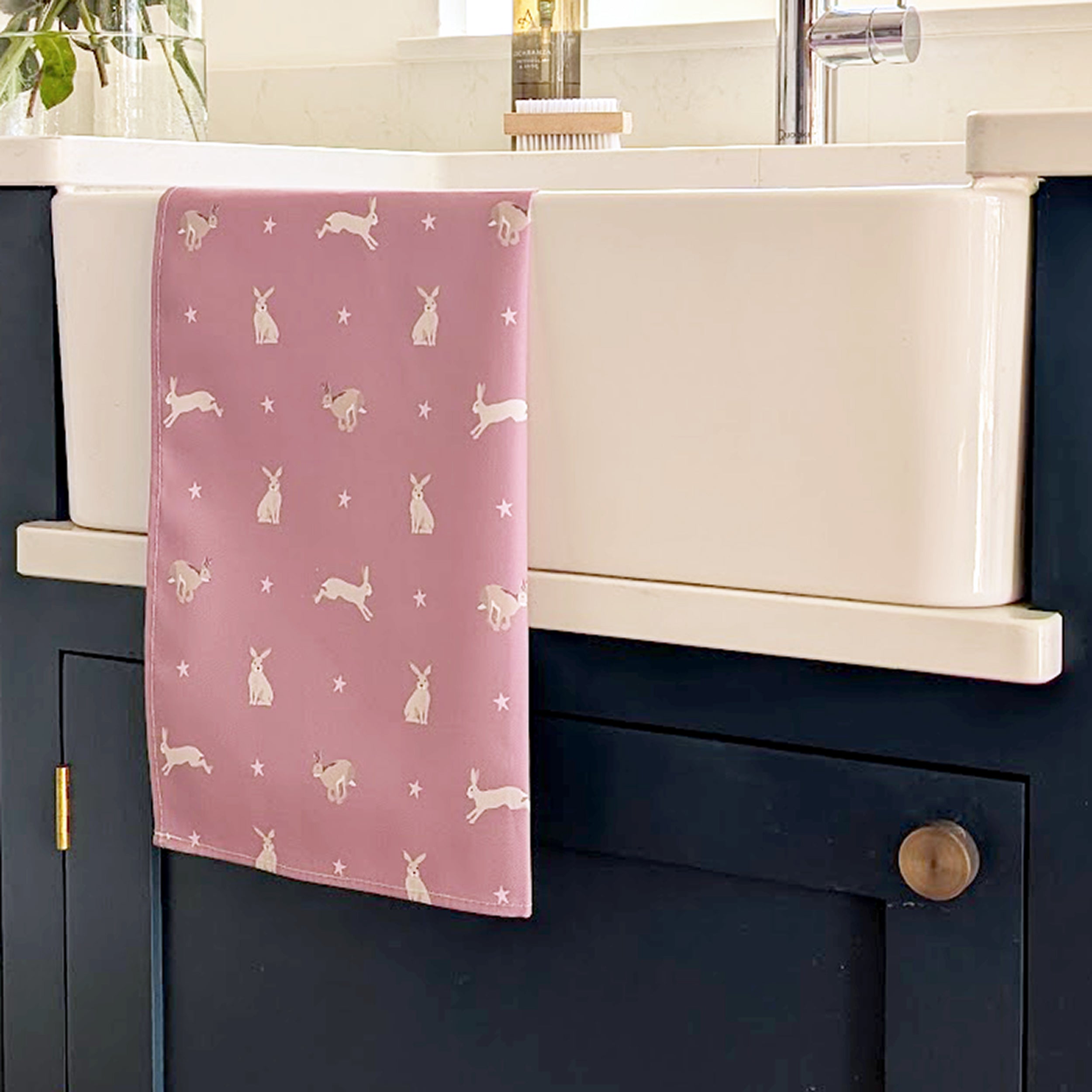 Pink hare design tea towel on a kitchen sink