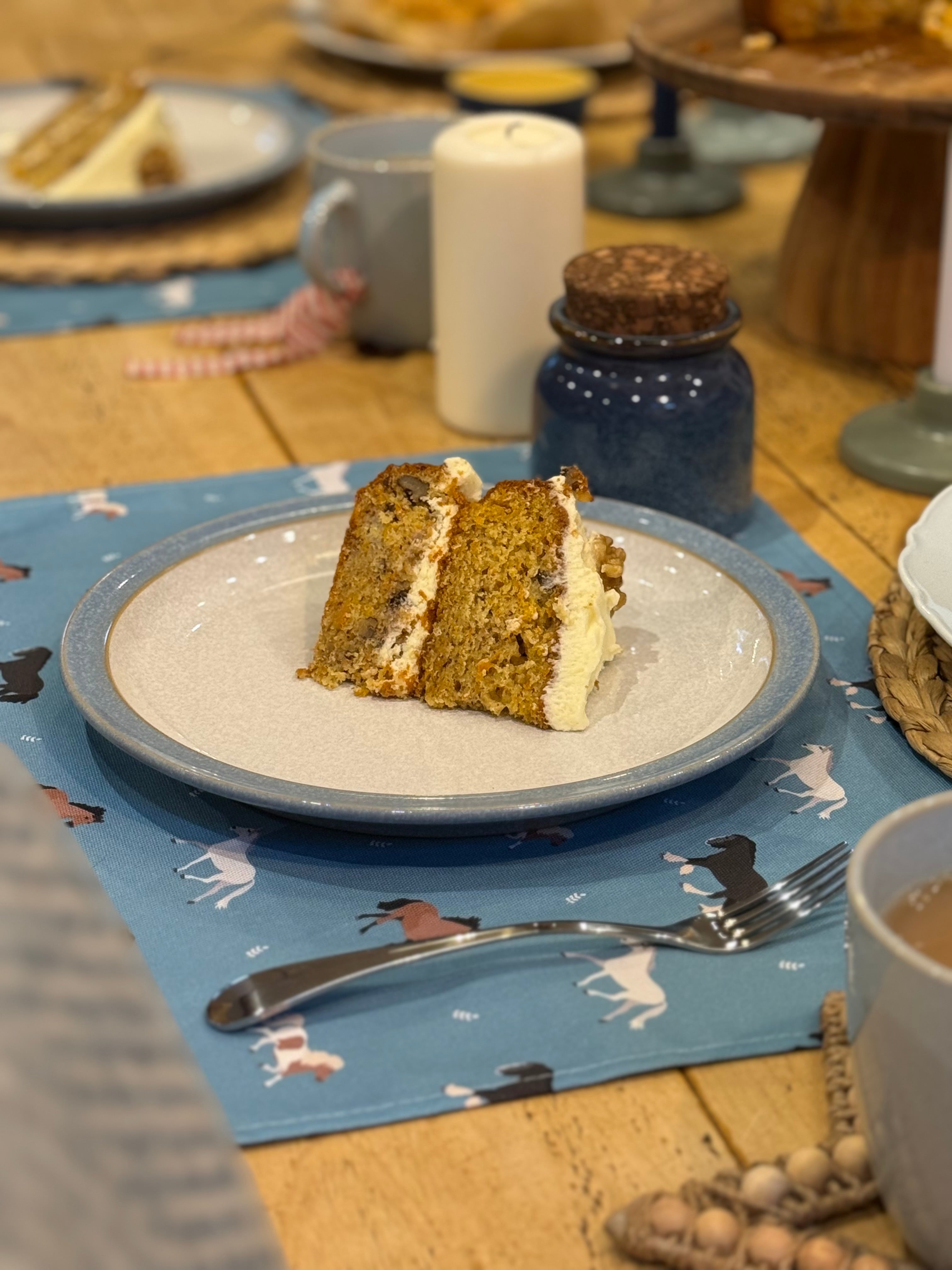Horse print fabric placemats underneath a plate with a slice of cake on it