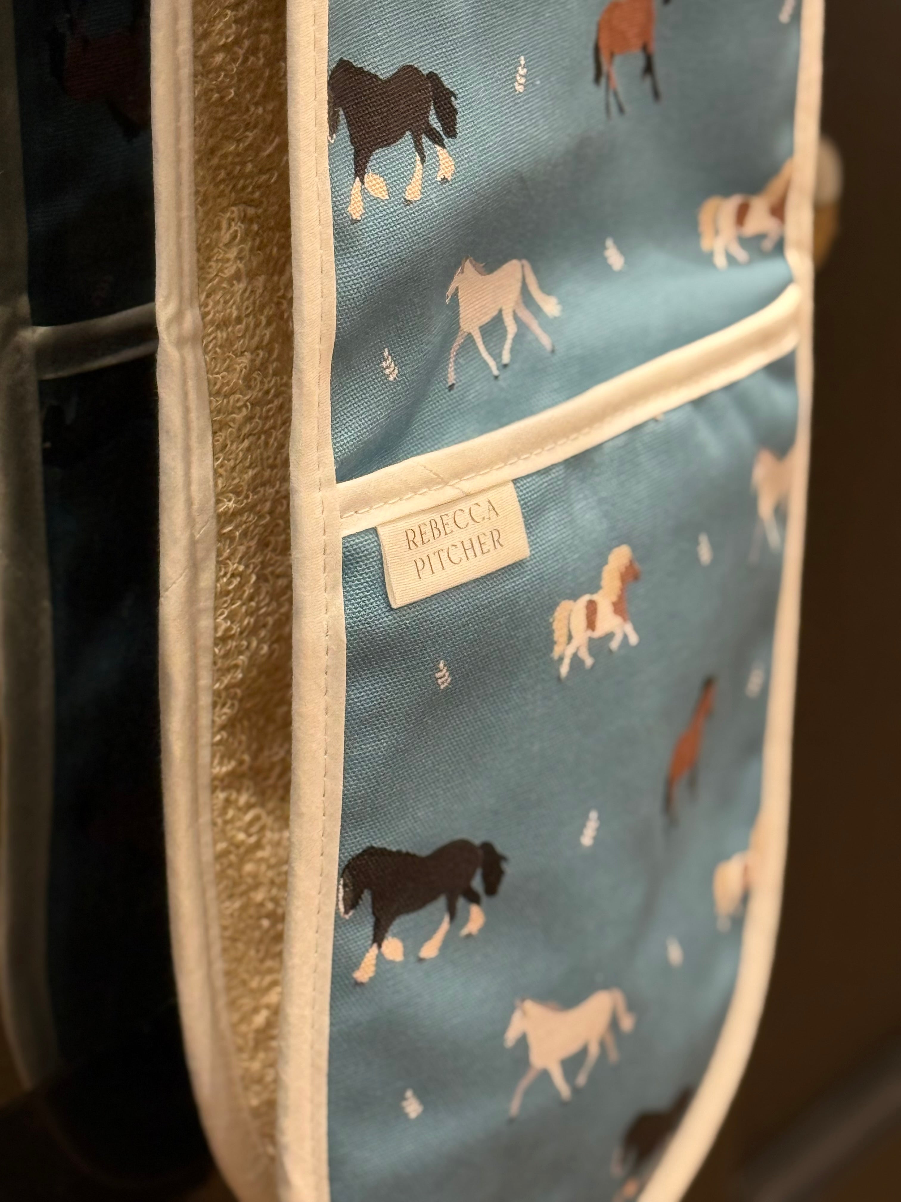 close up of blue horse patterned oven gloves