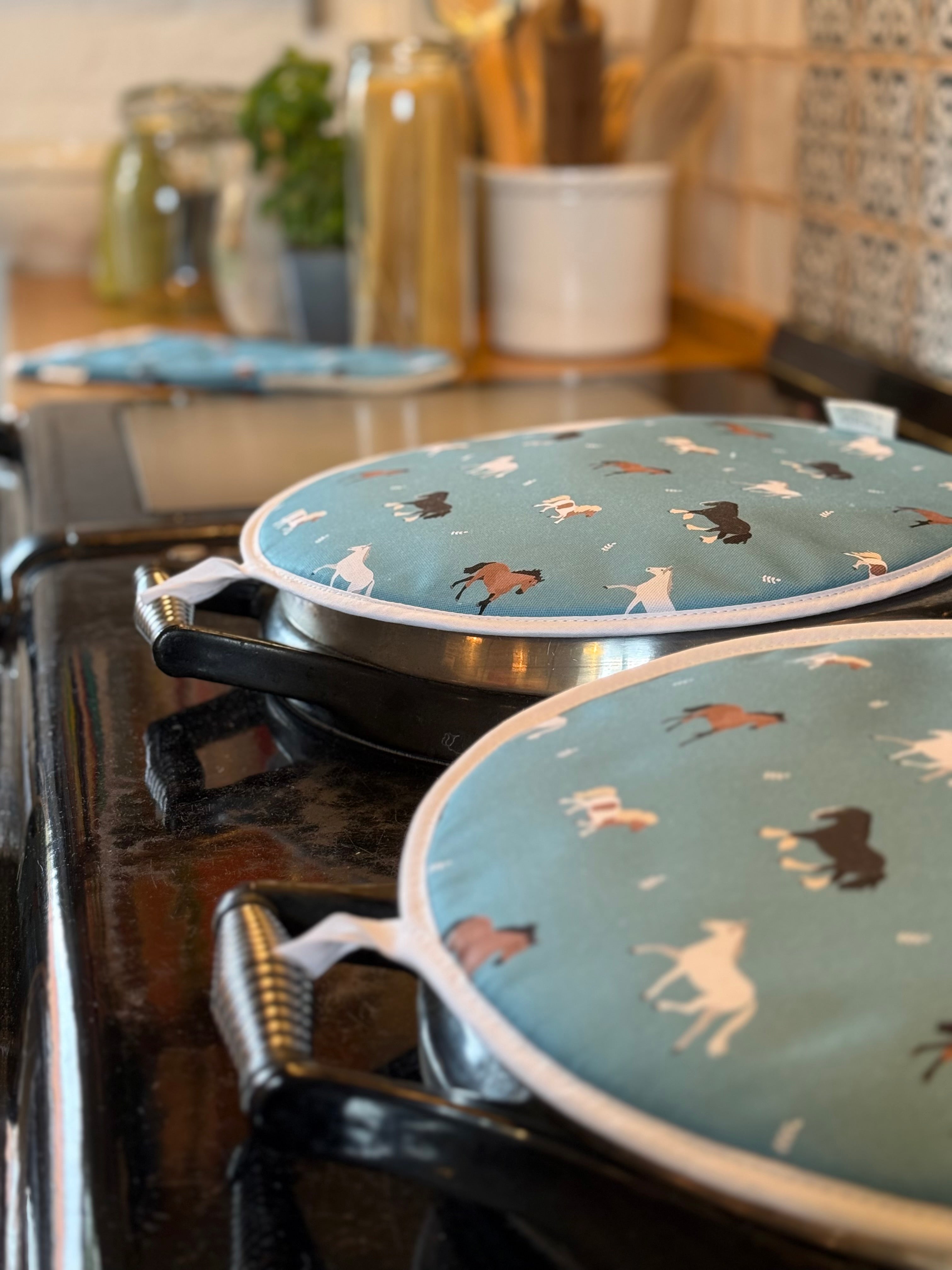 Blue horse pattern round hob covers on range cooker lids in a country kitchen