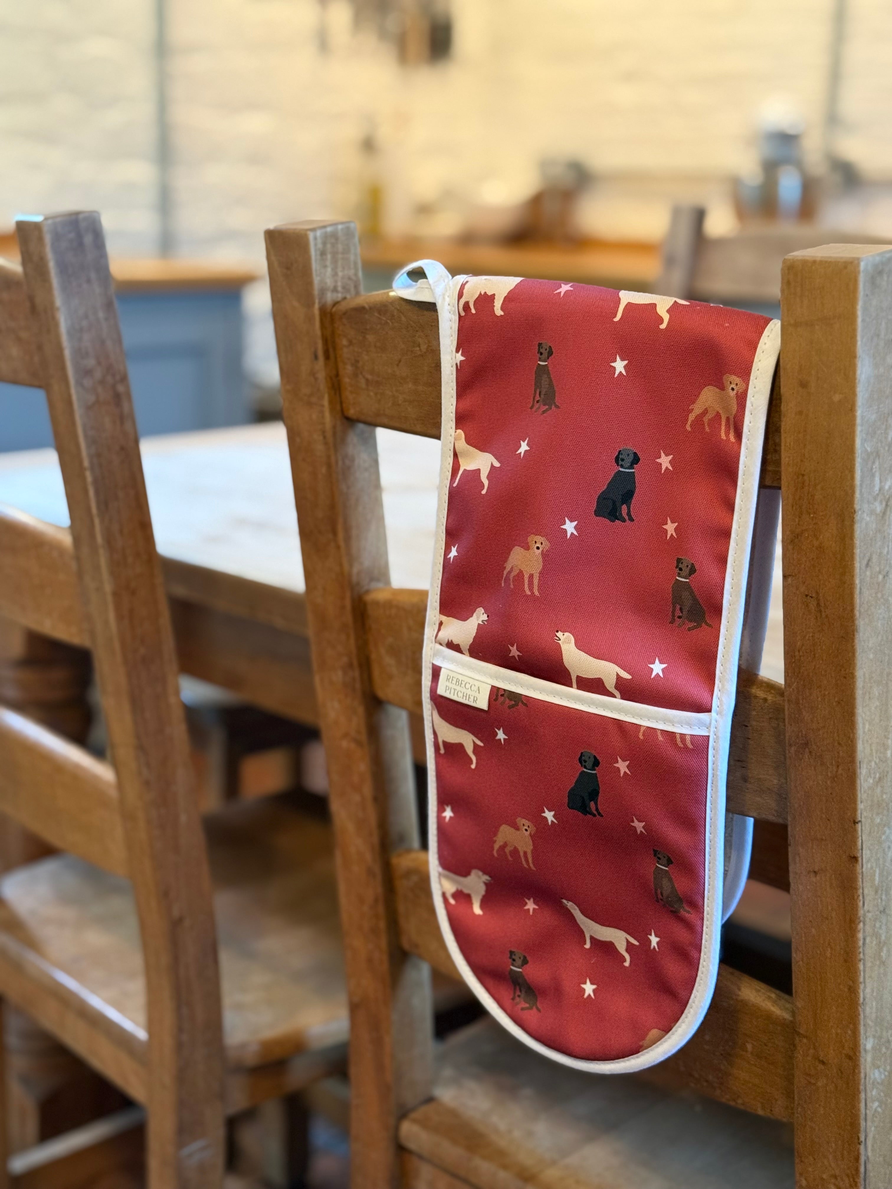 Red labrador design double oven gloves hanging over a wooden chair